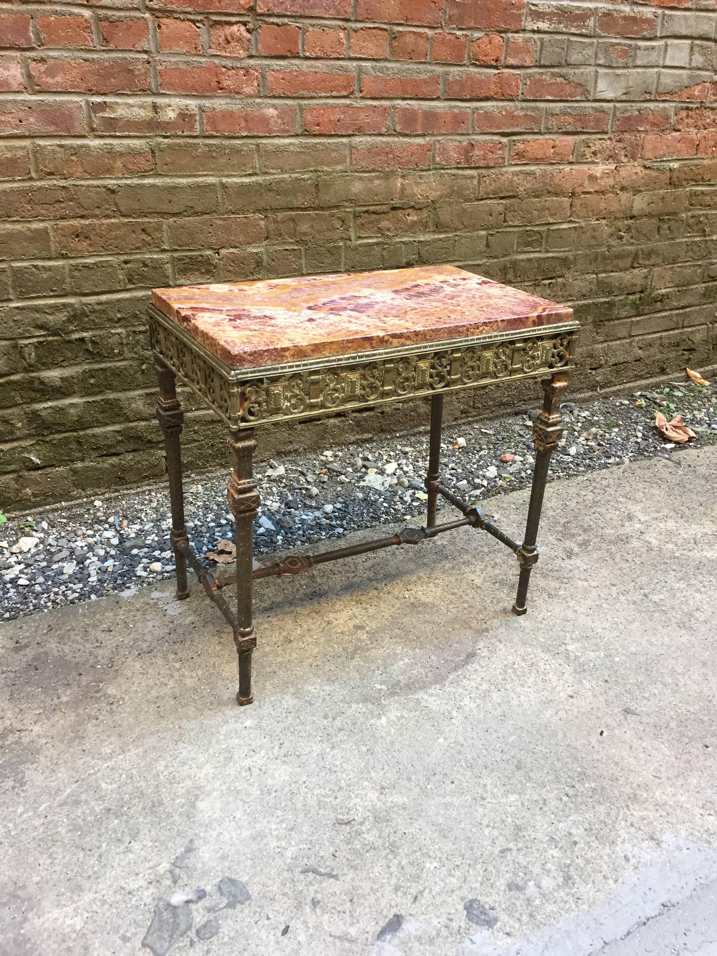 Wonderful cast iron and marble-top table in the style of Oscar Bach. Iron frame with rope twist legs, stretcher base and scrolled and cartouche decorated apron, circa 1910-1920.