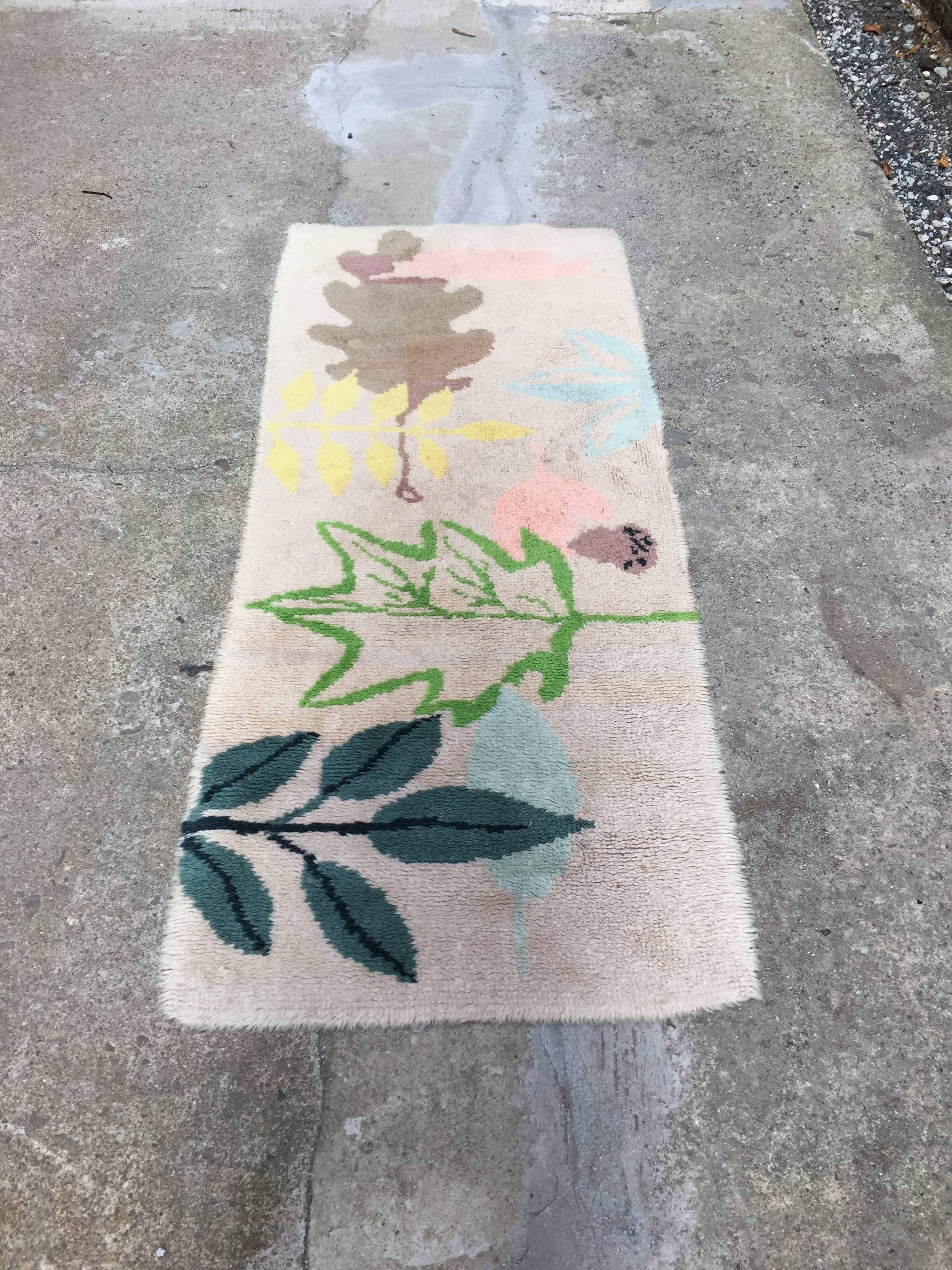 Beautiful modernist hook rug adorned with several species of tree flora. Cream color background with different tree leaves and an acorn. All handmade, circa 1950-1960.
