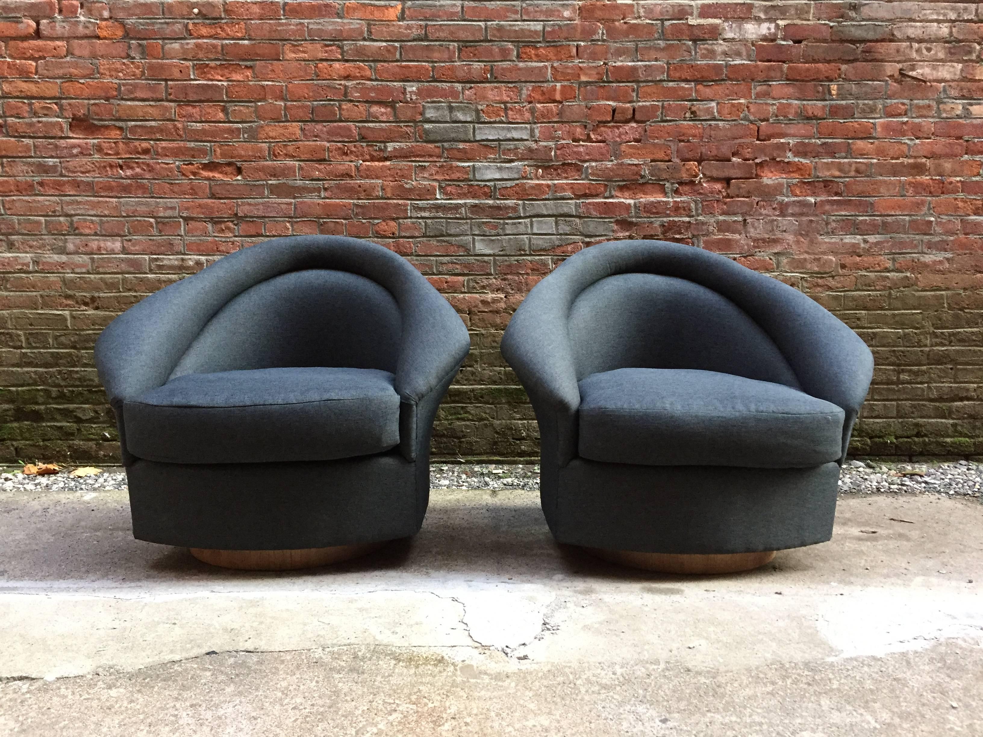 Re-upholstered in a Knoll charcoal grey fabric with round walnut bases. Very nice flared arm detail.