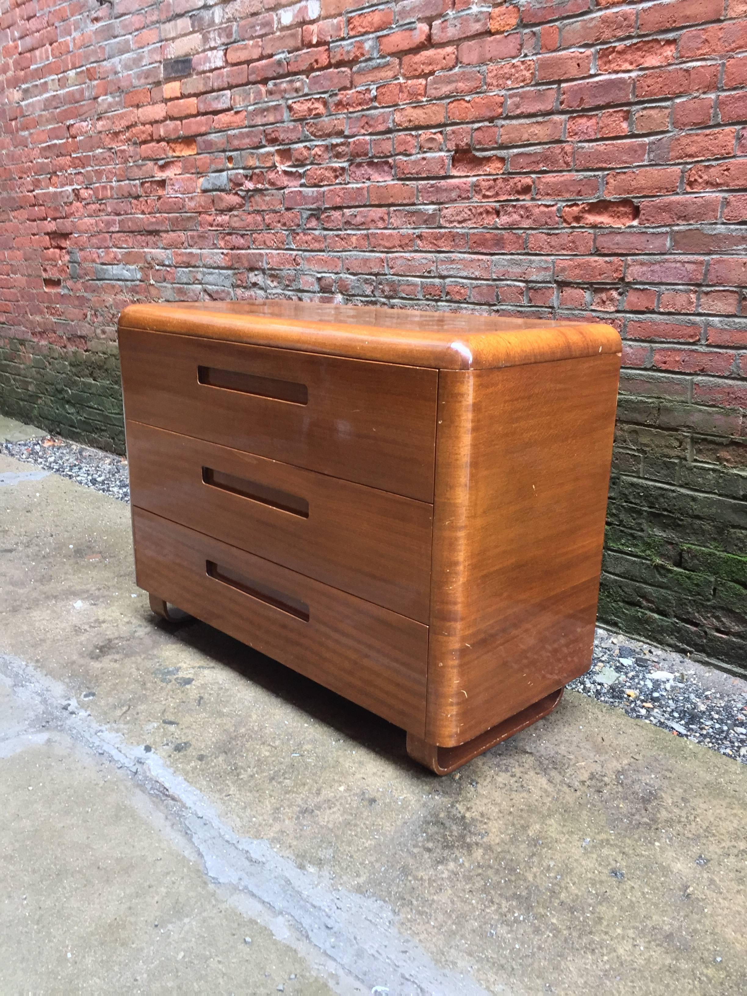 Amazing early bent plywood dresser designed by Paul Goldman for Plymodern Furniture. Plymodern was a division of Simpson Furniture Company. Plymodern would later become Plycraft. The three-drawer dresser is made of beautiful mahogany veneers over