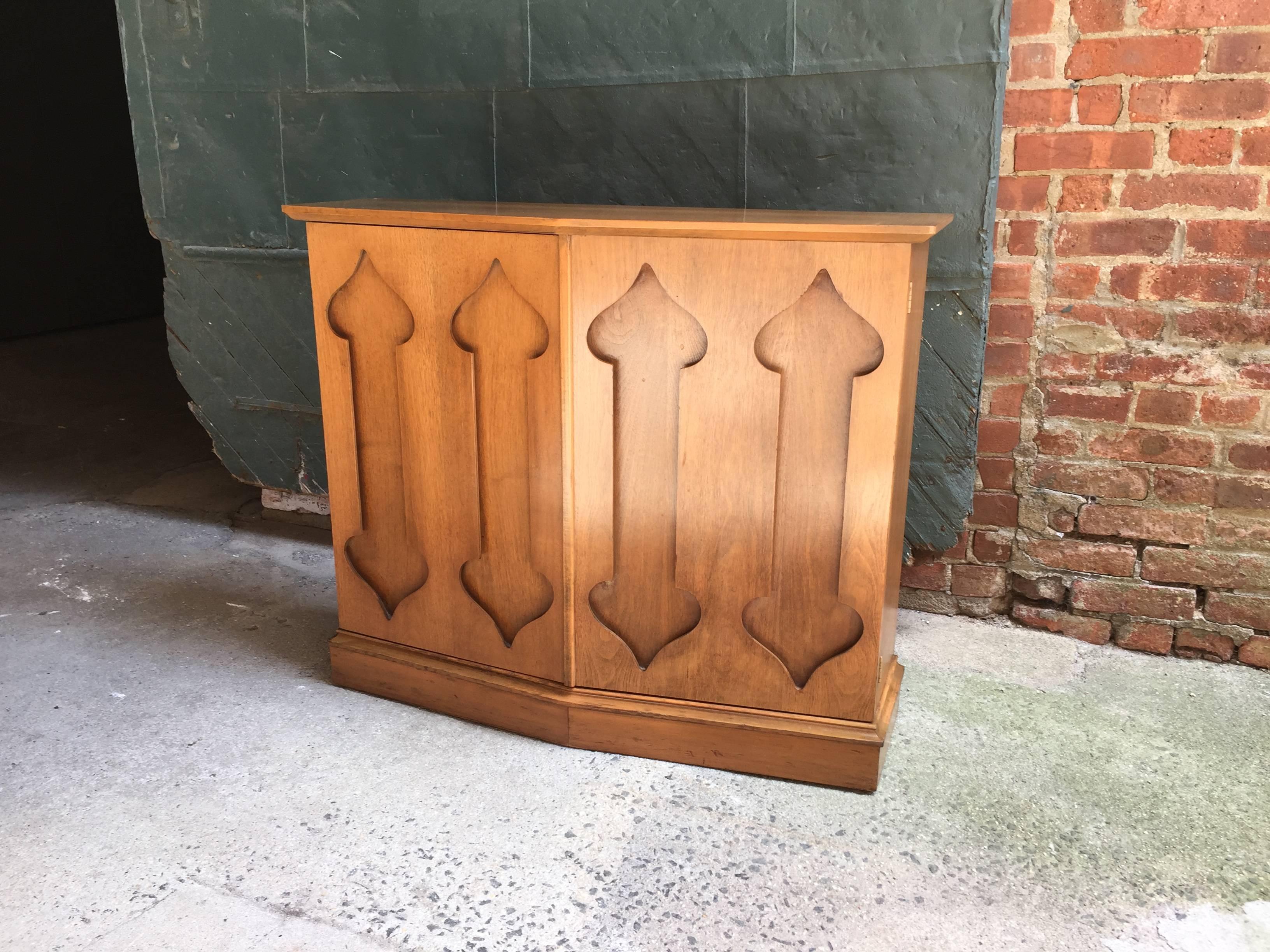 Mahogany two-door console cabinet with recessed trefoil design accents. Single stationary shelf interior. Chevron shaped top and cabinet, circa 1970. Unsigned.