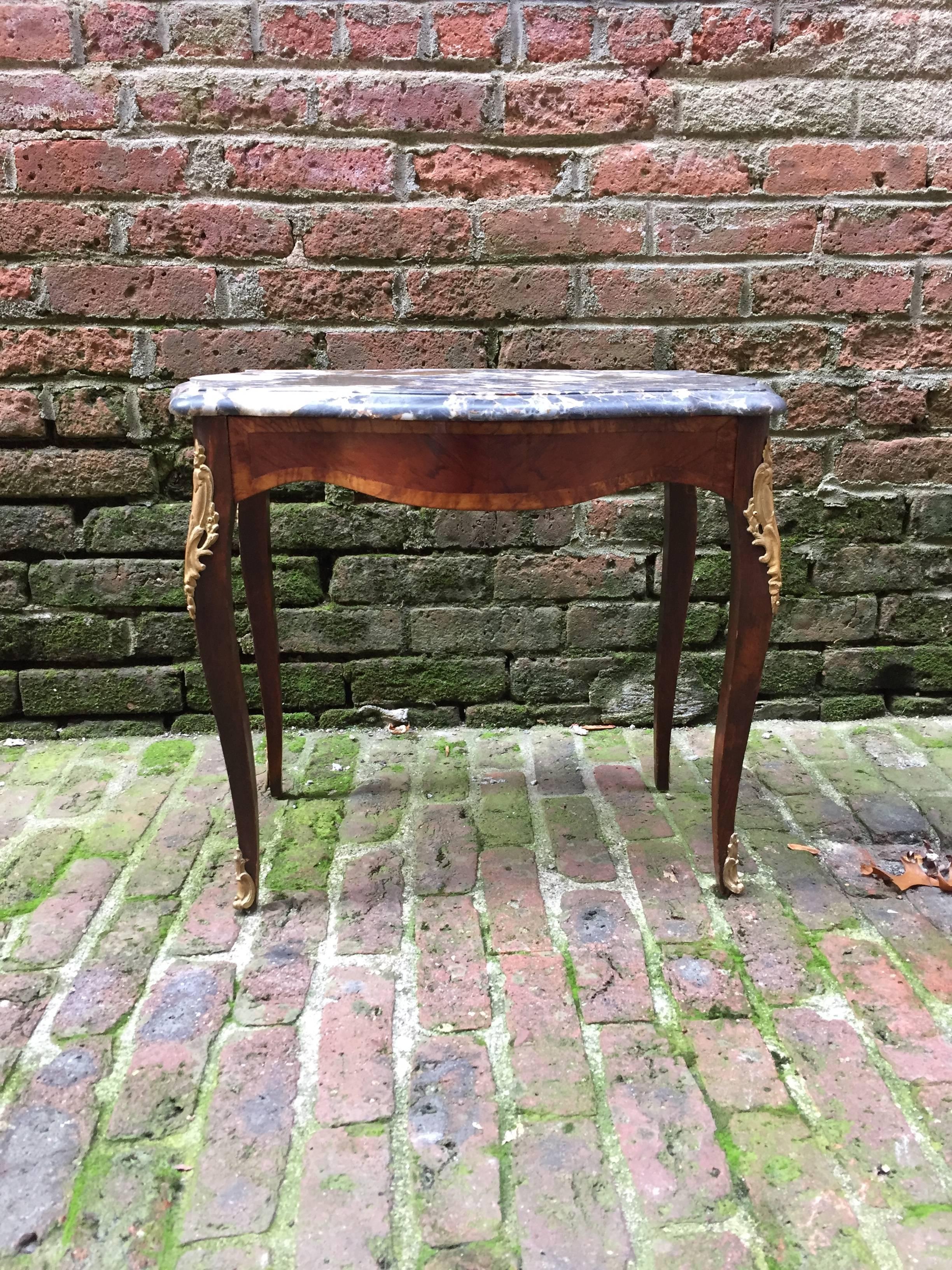 Quality 1950s, Louis XV reproduction with featuring inlaid bombe support with ormolu mounted cabriole legs with a wonderful piece of Breche marble. Ink stamped, France on the inside stretcher. Satinwood, fruitwood and walnut veneers, circa