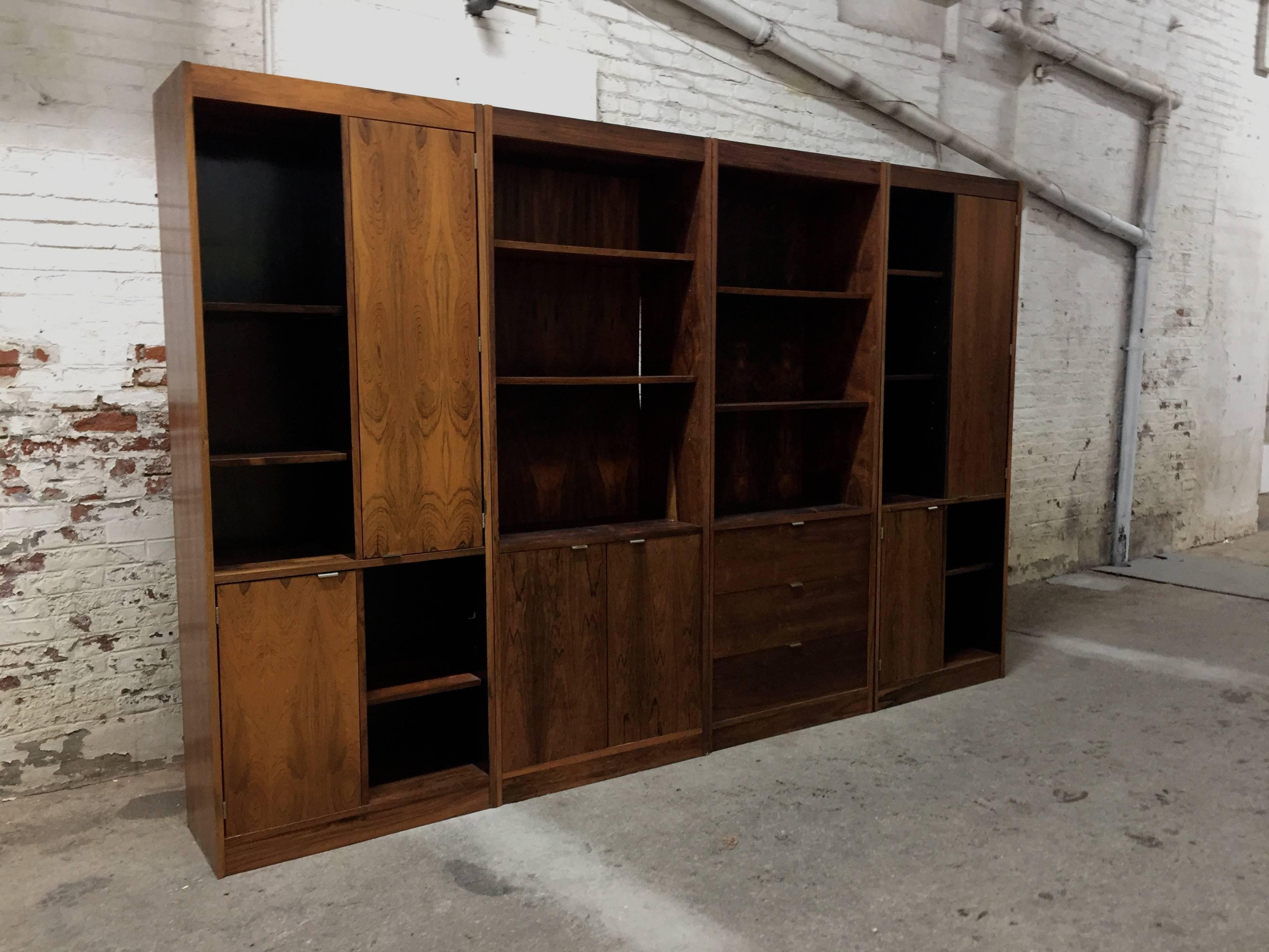 Four beautiful figured Rosewood cabinets all with adjustable shelving. Interior sides of the cabinets have an ebonized finish. Two cabinets consist of a top and bottom door with removable and adjustable interior shelves. One cabinet consists of