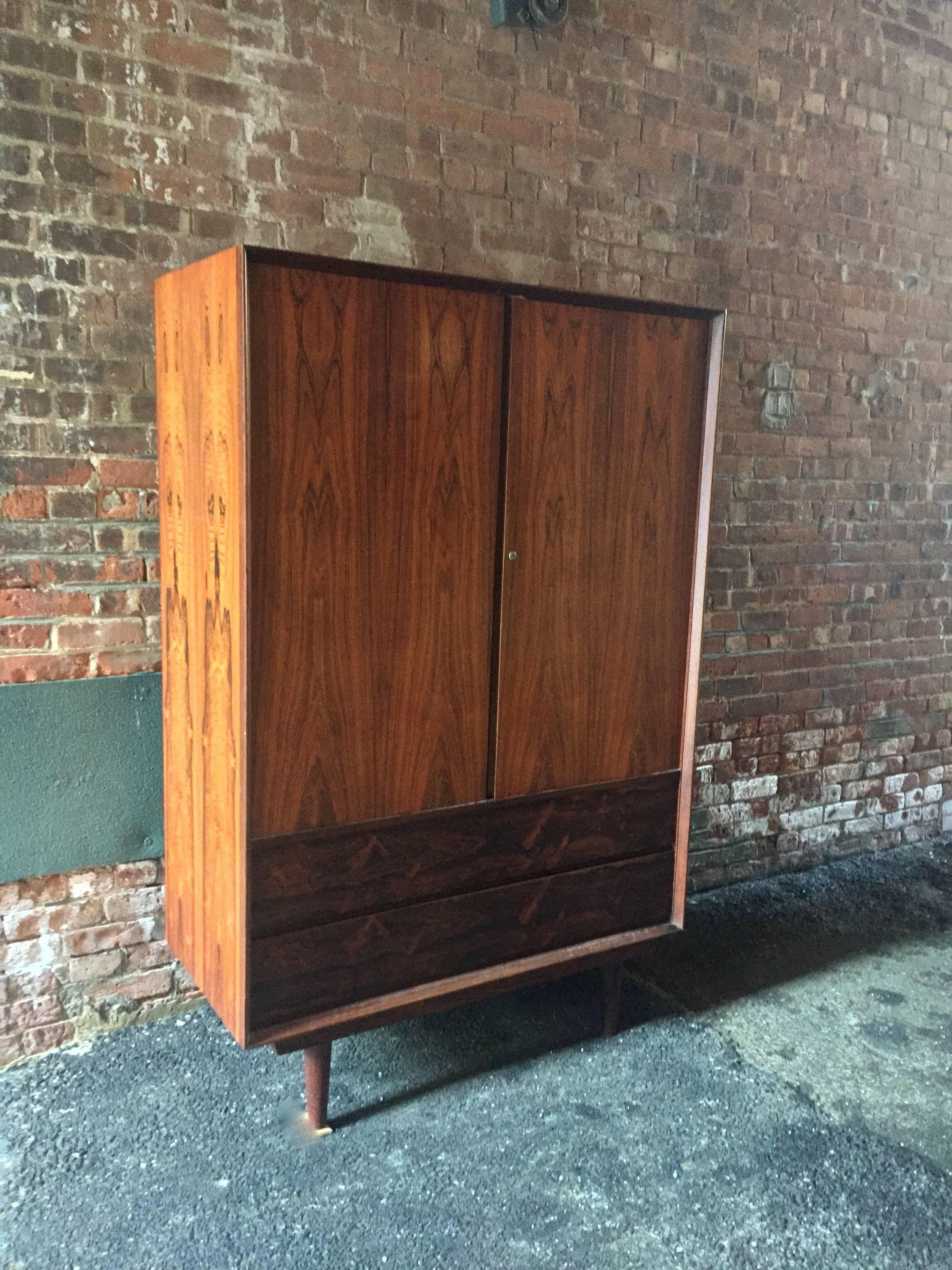 Tall Danish modern rosewood cabinet. Two long drawers on the bottom with three hidden drawers with four large interior cubby holes, circa 1960-1970. 

Please, take the time to view the other rosewood pieces from this spectacular bedroom