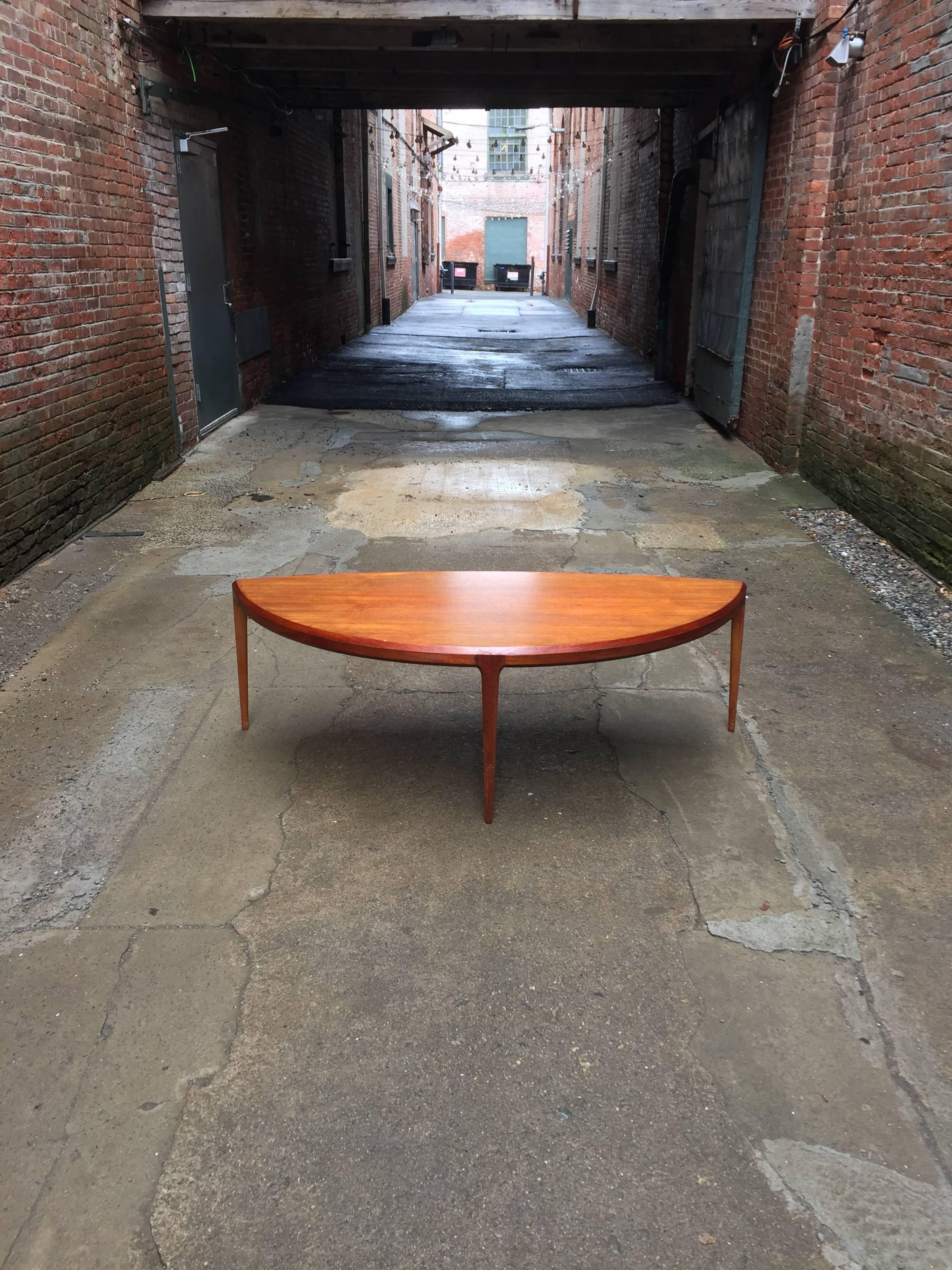 Tapered legs, beveled edge and exquisite teak top design by Johannes Andersen for CFC Silkeborg, Denmark. The table also features a wonderful curvilinear form supported by three legs. The table definitely has presence. Fully signed with enamel
