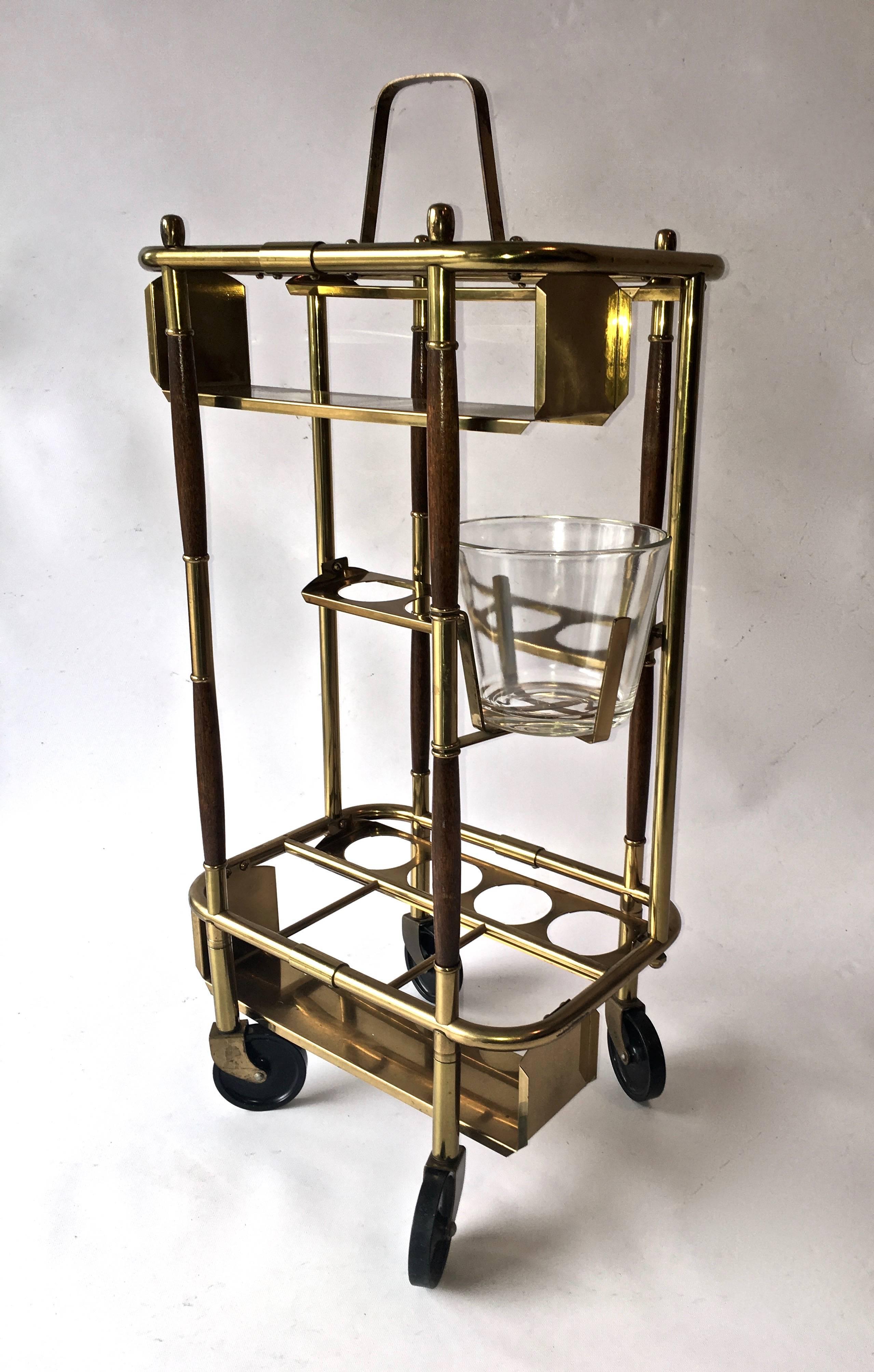 Warm patinated brass and dark wood, with a swivel out ice bucket, complete this gorgeous and functional little bar cart. Handy moveable bar service able to hold glassware, wine/liquor bottles, and ice.