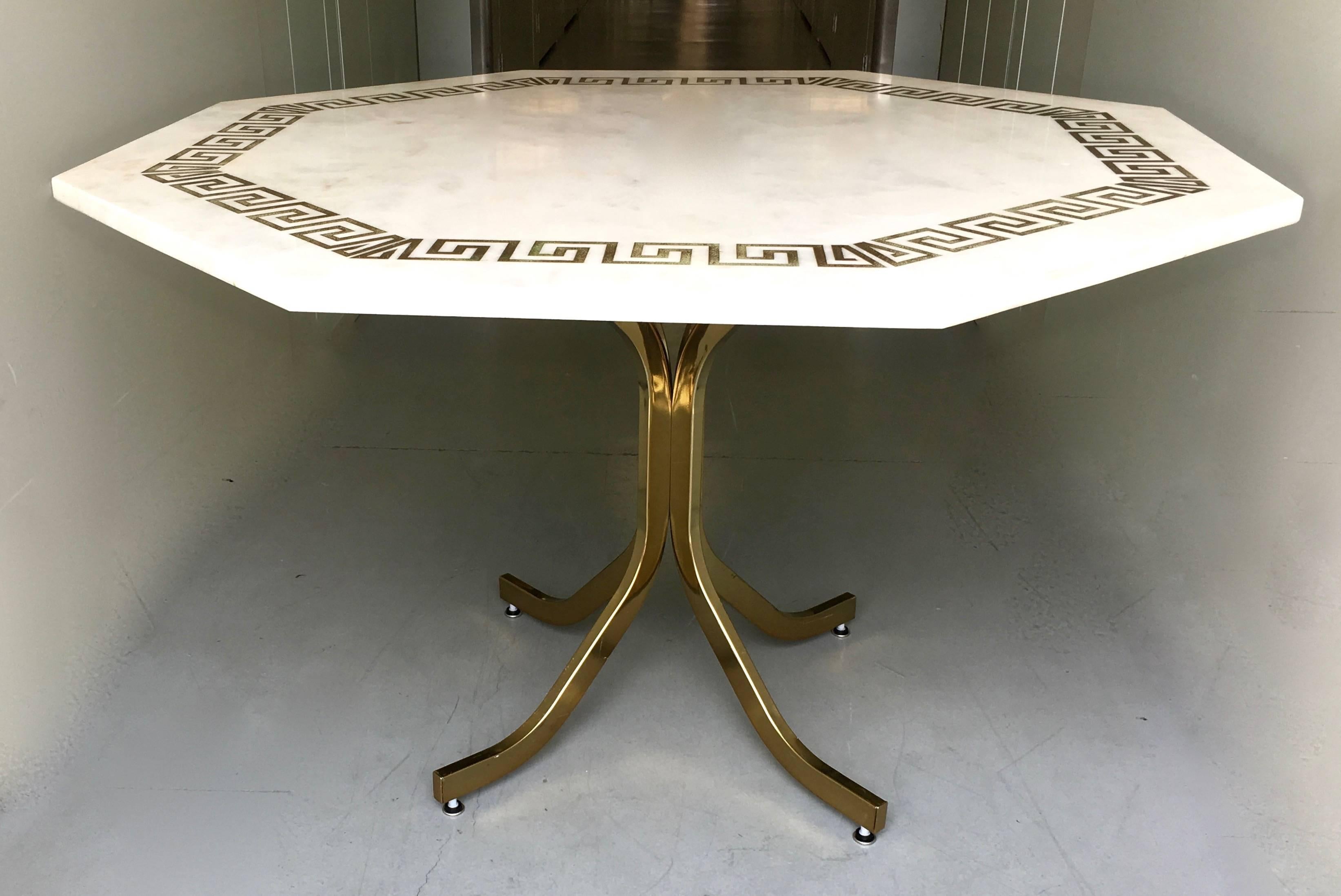 Gorgeous white Italian marble table with etched gilt Greek key border design. Flexible size and design that enables it to be used for an entry table, or dining table.

A stunning piece of subtly mottled marble, sits atop a brass base, with