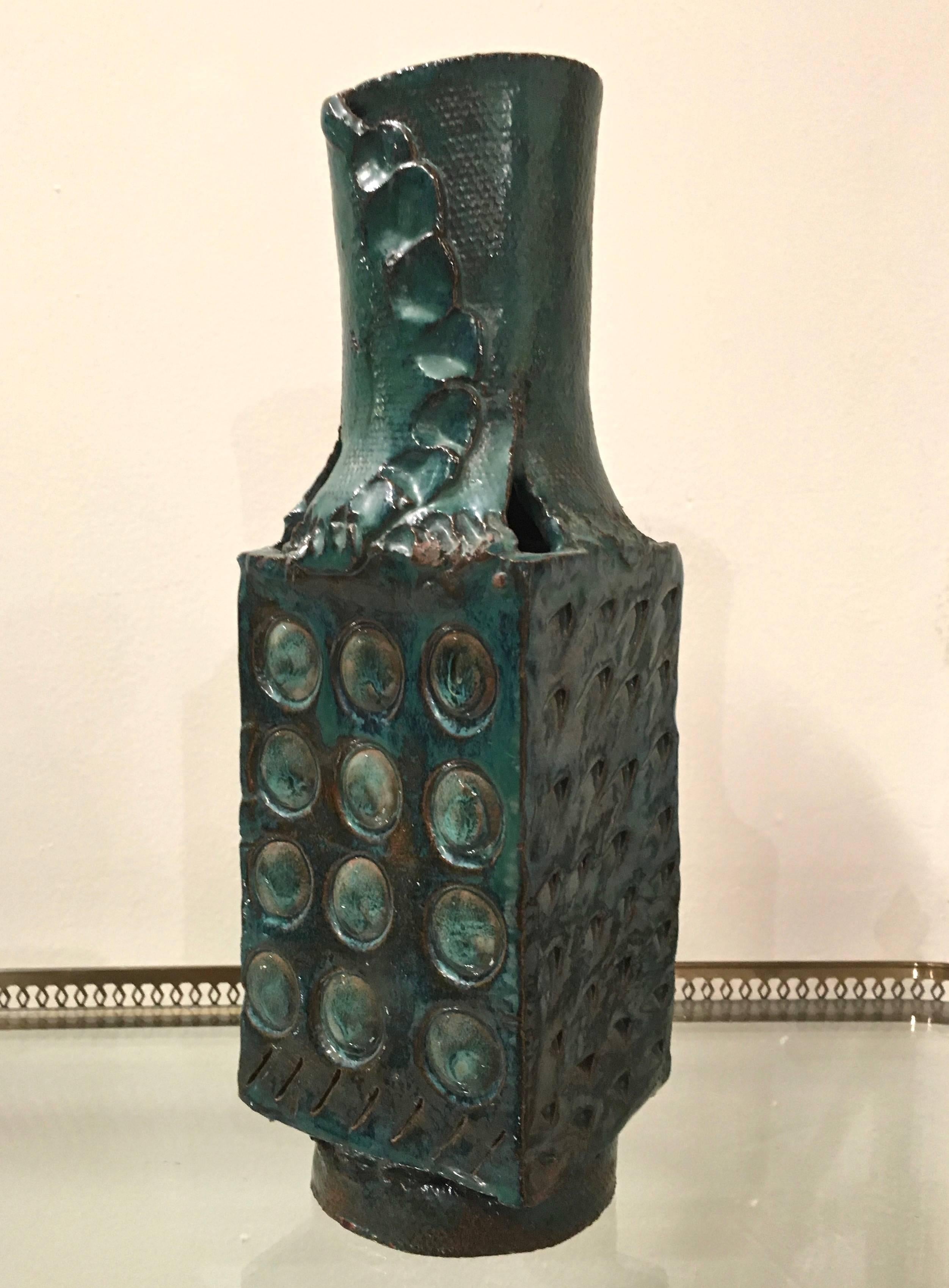 Amazing vintage modern, handcrafted pottery sculpture. This piece has a gorgeous blue green glaze, with bits of the textured terra cotta clay color peaking through. The handmade nature reveals itself in the incised geometric design, textured base