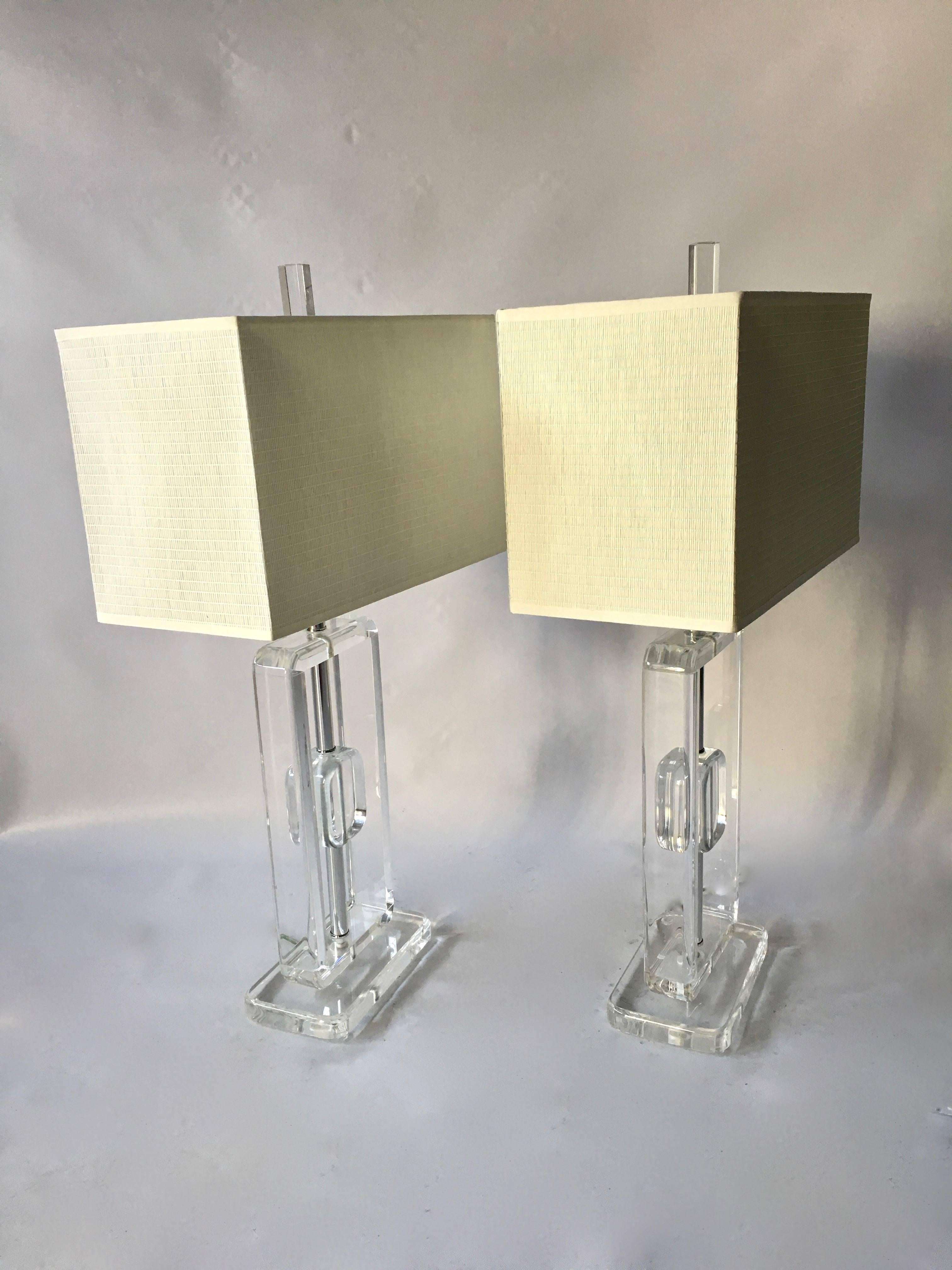 Great pair of vintage Lucite table lamps in the manner of Karl Springer with original box shades and Lucite finials. Rectangular frame and base, with great thick profile and floating inner rectangular Lucite gem. 

Base measures 9