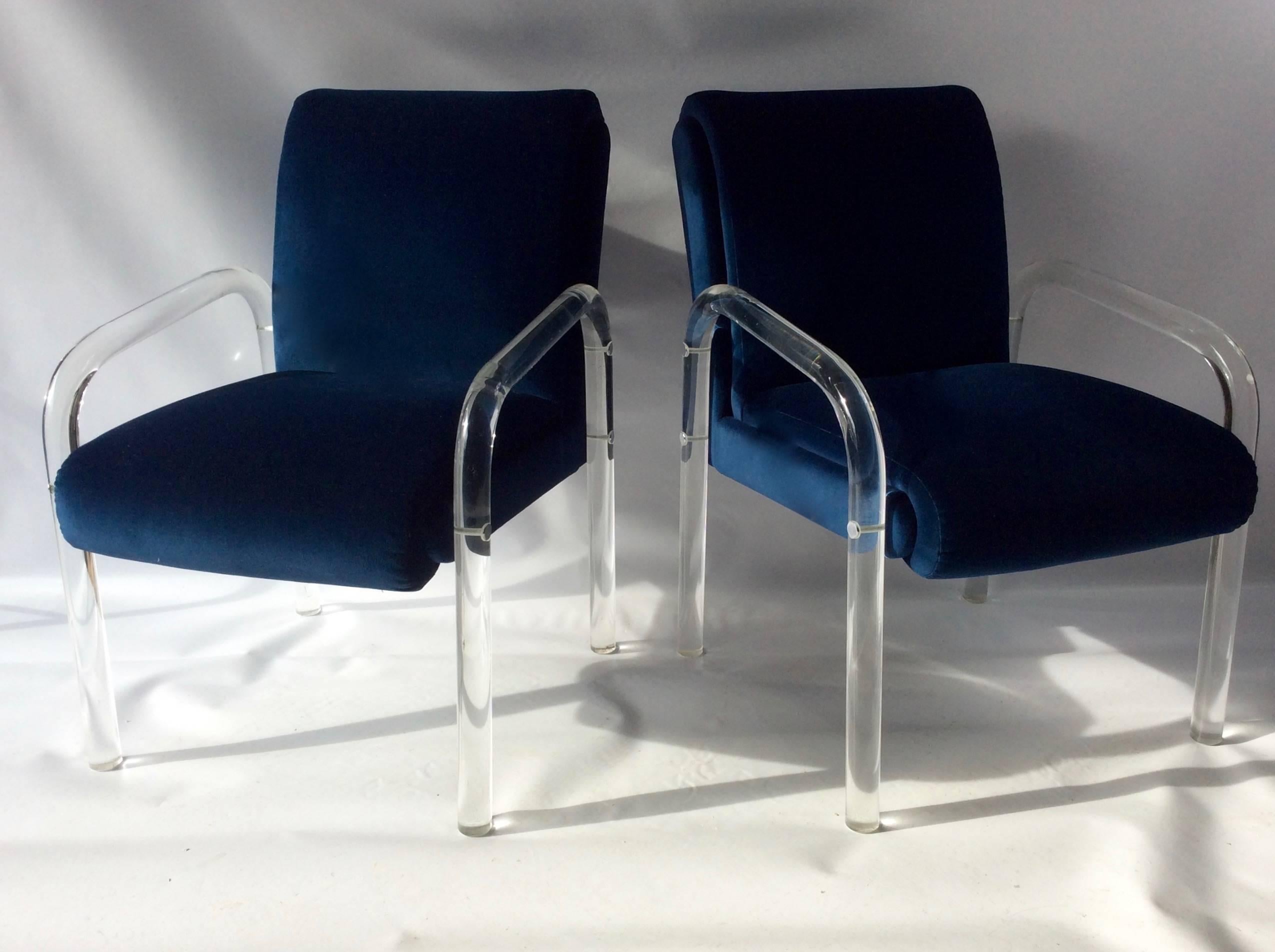 Pair of vintage lucite arm chairs newly upholstered in crisp navy blue velvet.  Fantastic condition, unsigned attributed to  Charles Hollis Jones, and /or Lion in Frost. Stylish and comfortable sitting chairs with lucite frame, finished with small