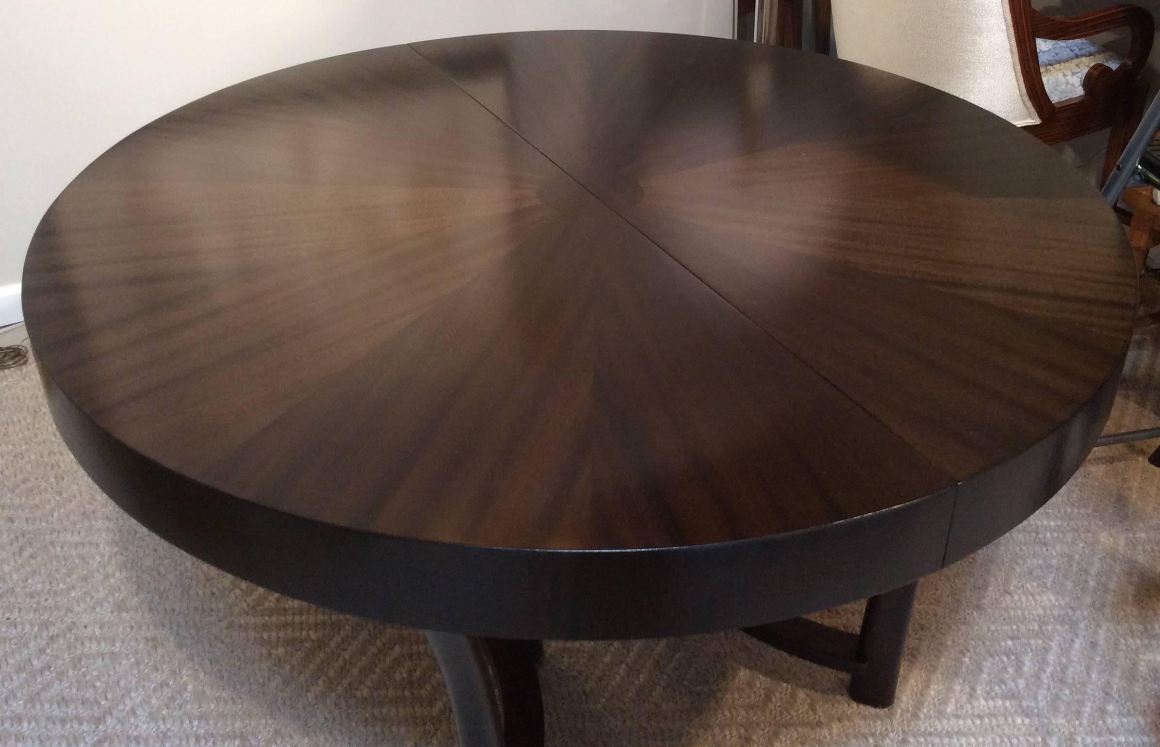Magnificently refinished walnut dining table with unusual starburst veneer top and one extension leave. Designed by T.H. Robsjohn-Gibbings for Widdicomb, USA, circa 1940s. This table can be transformed from round to elongated oval by the additional