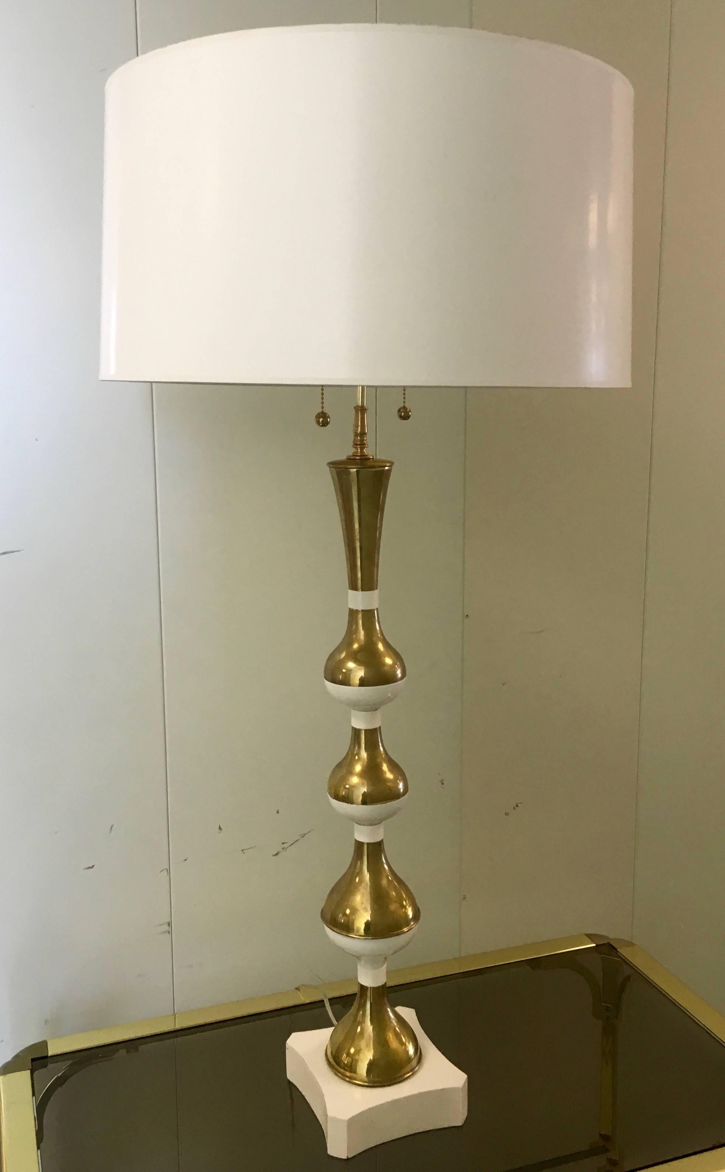 Fabulous manner of Tommi Parzinger, sculptural table lamp with warm white toned enameled graduating size orbs, with patinated brass counterparts. Newly rewired with new white and gold lined drum shade. New double sockets with polished brass pull