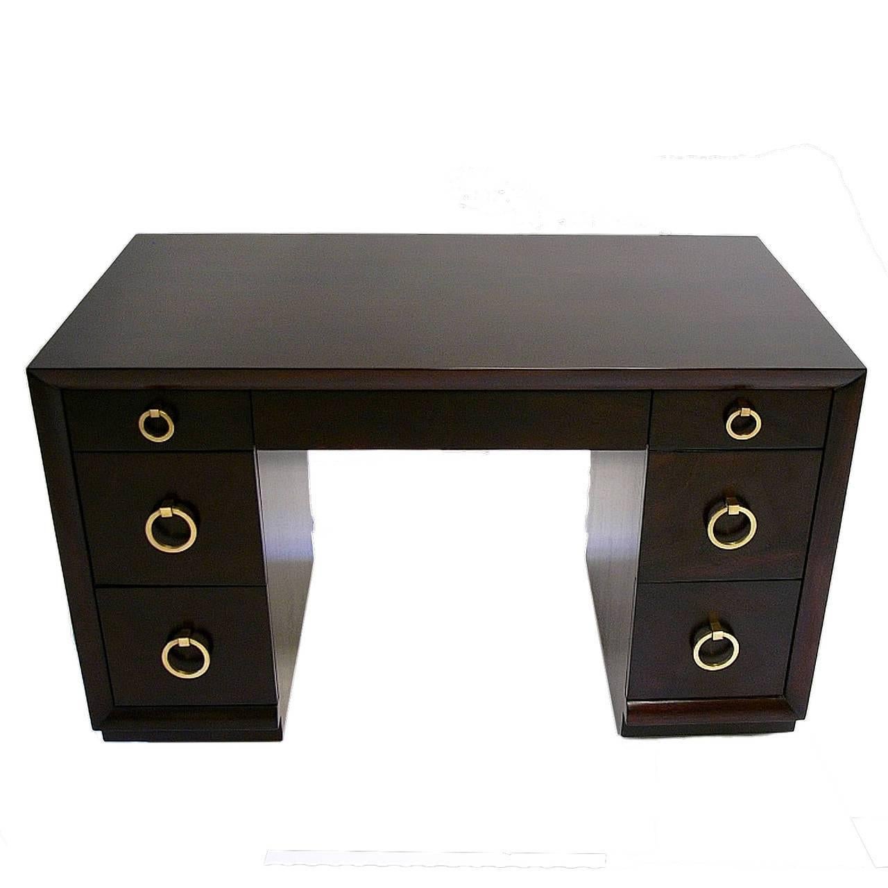 A Classic kneehole desk, completely re-finished on both sides in a sable brown stain. Polished signature round brass door knocker drawer pulls and a centre pencil drawer. Original brass label and paper tag intact. Model no. 317, by T.H.
