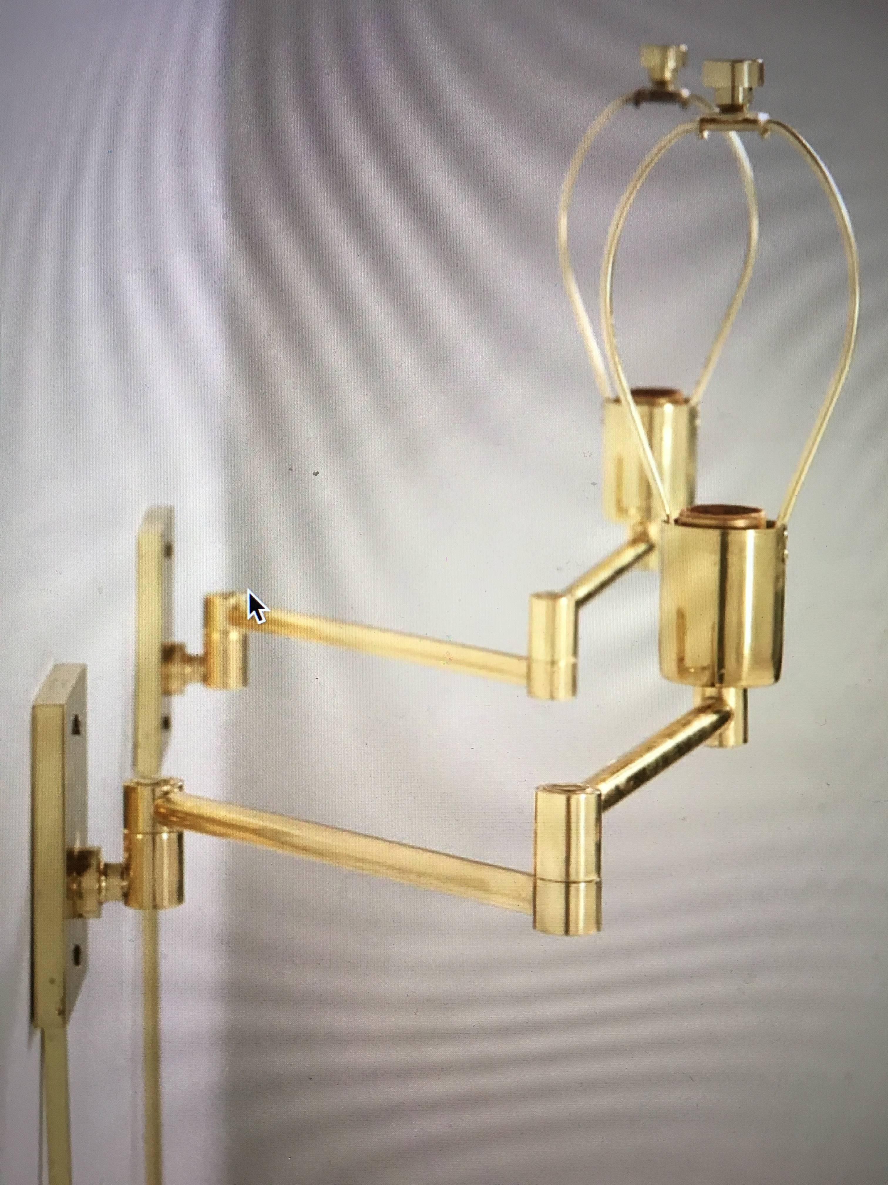 Pair of double swing arm wall lamps designed in 1947 by George W. Hansen for Hansen Lamps New York. Manufactured by Metalarte. Original cast brass markers mark stamp, on backplate, and top of backplate 