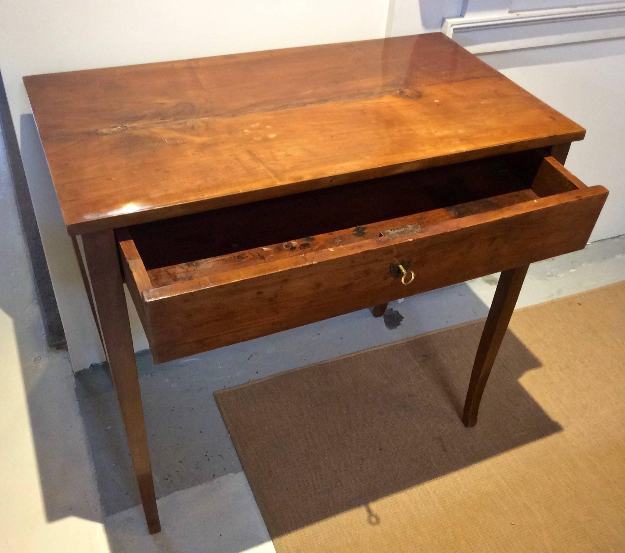 Lovely antique table, from published home in Architectural Digest designed by Jeffrey Bilhiber. Writing table has beautiful warm honeyed patina, tapered legs and original lock and key, and if selected by Mr. Bilhuber, than you know its of fine