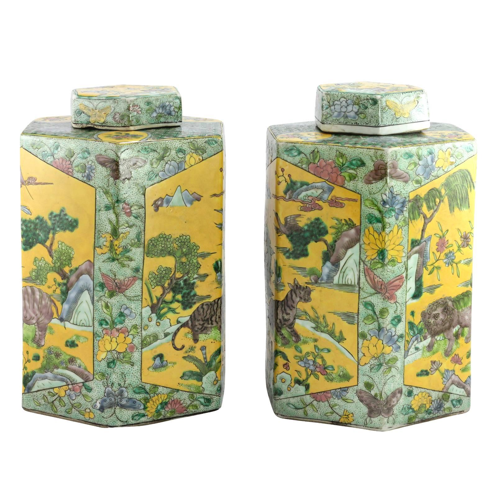 A pair of late 19th or early 20th century Chinese famille verte hexagonal lidded jars, marked and completed in a Kangxi style. The piece depicts a variety of creatures such as tigers, elephants and lions; in overglazed yellow, blue and aubergine