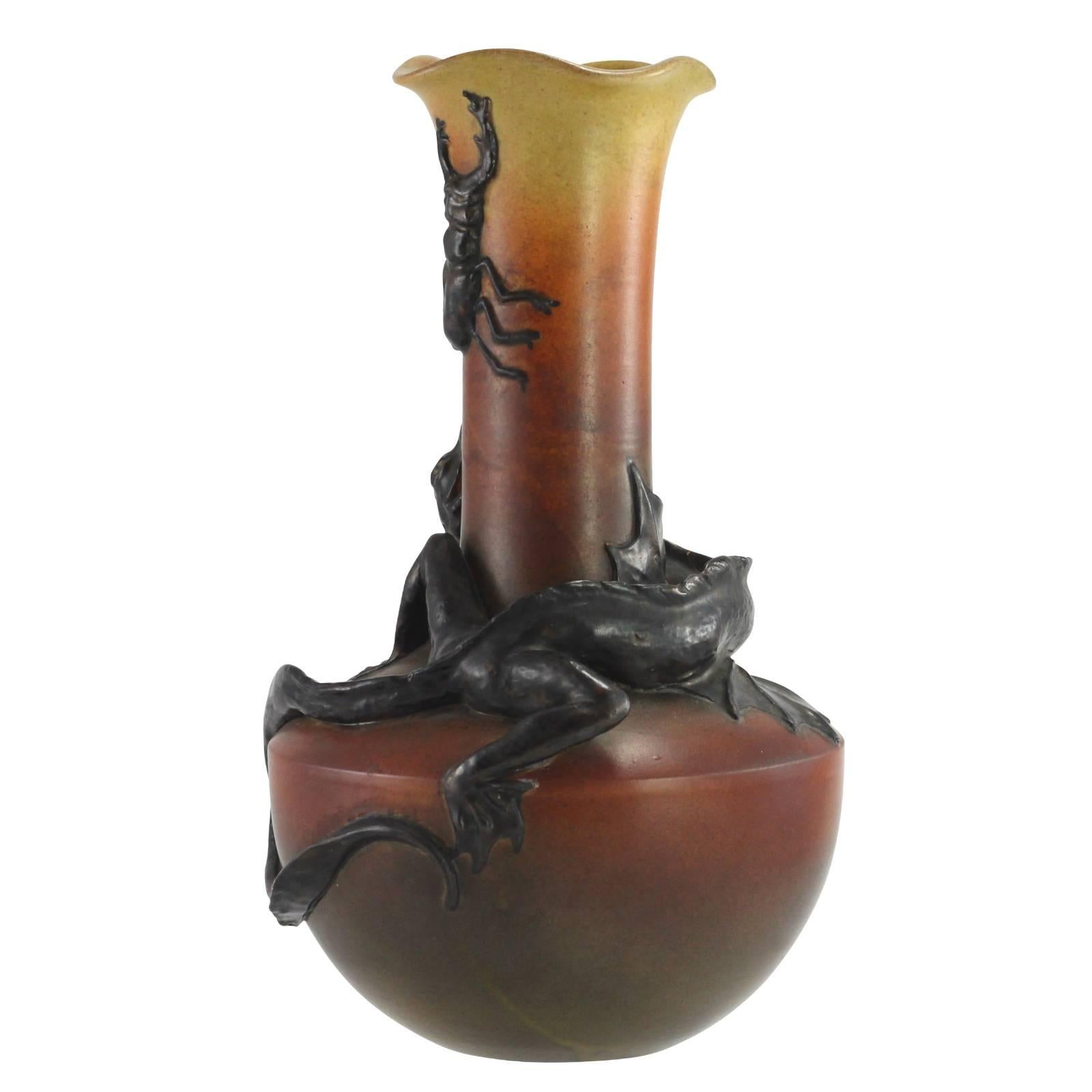 A Danish Art Nouveau vase featuring a brown to red to yellow ground, mounted with a large stag beetle and lizard. The piece is stamped “P. Ipsen. Kjobenhavn. 331″. After Ipsen passed away in 1860, his wife, Lovise, took over the factory until their