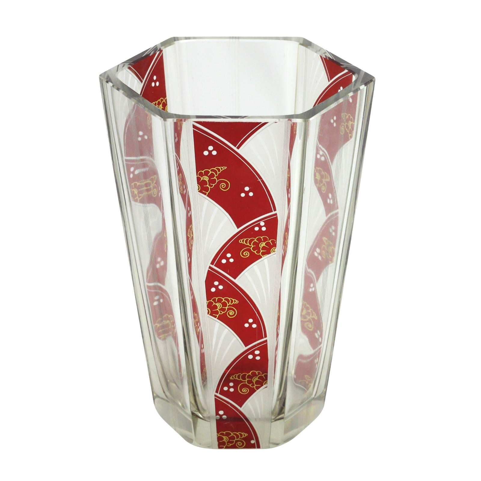 An Art Deco hexagonal shaped vase with reserve panels of flashed ruby glass fans. The gold blossom decoration to each fan references a Japanese aesthetic popular at the time.