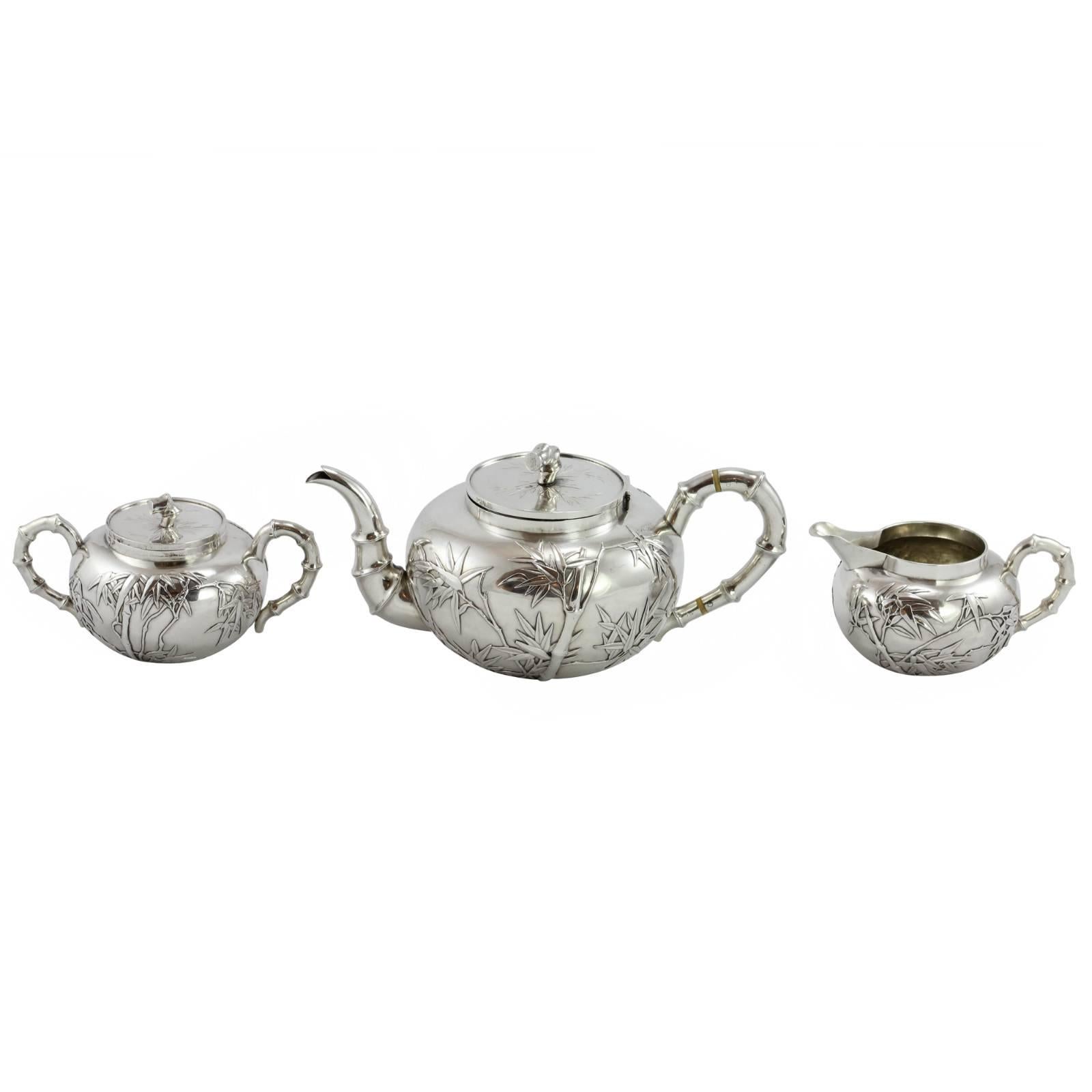 An early 20th century 3 piece Chinese export silver tea set, by Hong Kong based retail silversmith Wang Hing. The piece features a prominent bamboo motif, with the handles, finials, and teapot spout completed as bamboo stalks. The sides of the