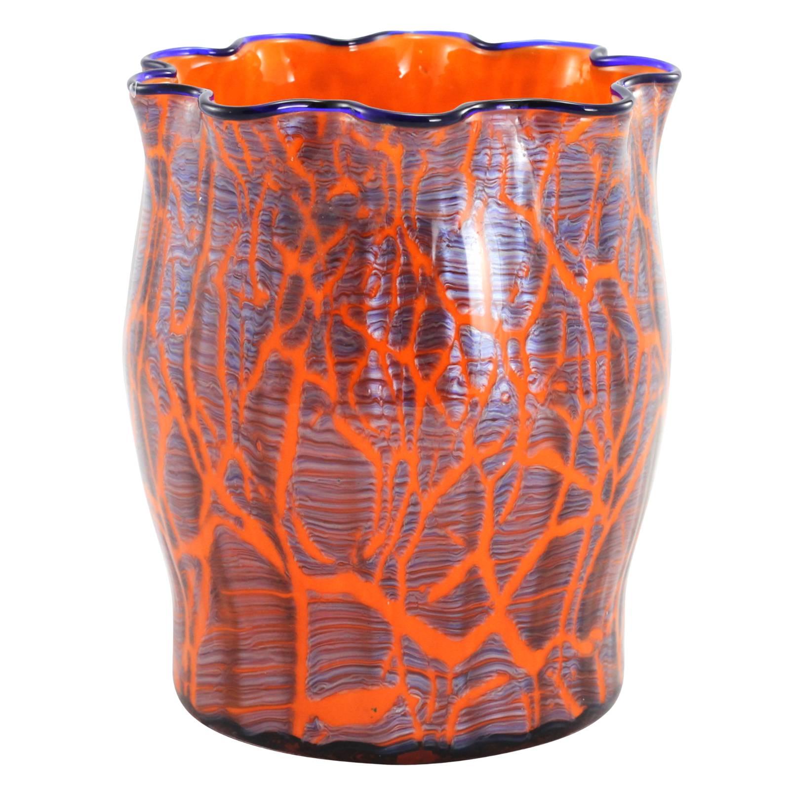 An early 20th century Bohemian art deco glass vase by famed European glassmakers, Loetz. Completed with an orange ground and cobalt blue rim; the vase is decorated with an overlaid steel grey crackle layer from the 'Ausfuehrung 134' decor. Because