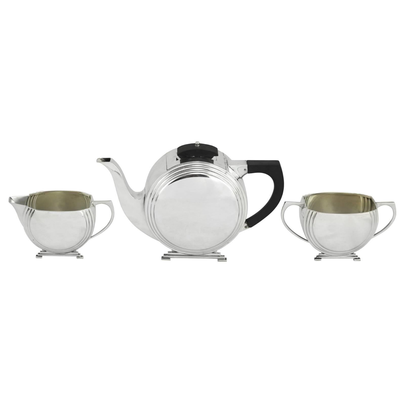 An early 20th century Art Deco sterling silver tea set by Joseph Gloster Ltd of Birmingham. This three-piece tea set displays Classic Art Deco design features, such as bold lines, symmetry, and contrasting elements of silver and ebony.