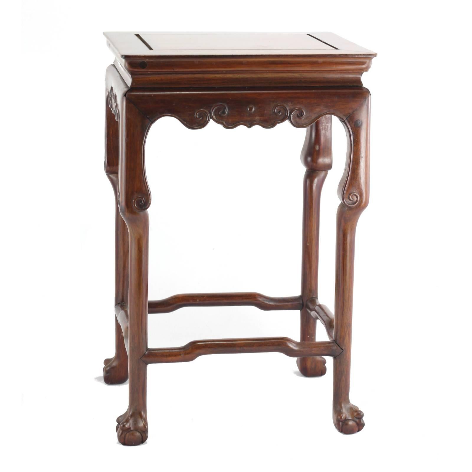 A set of three Chinese rosewood nesting tables, dating to the first quarter of the 20th century. Each table features four ball and claw feet, as well as a simple yet elegant scroll apron.
