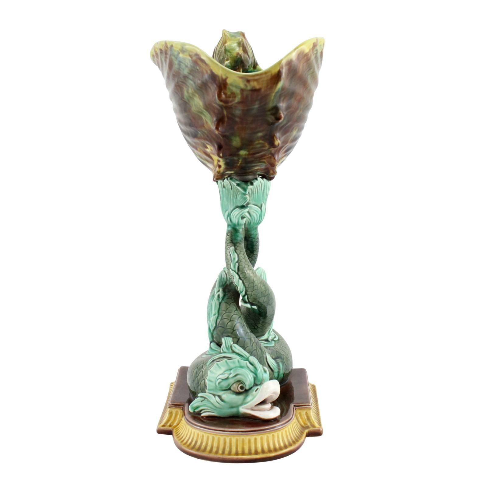 A large 19th century Wedgwood Majolica compote, in the form of two entwined dolphins supporting a nautilus shell with their tails. This refined centerpiece displays a great range of colors typical to Majolica ware at the time, such as Monte Carlo