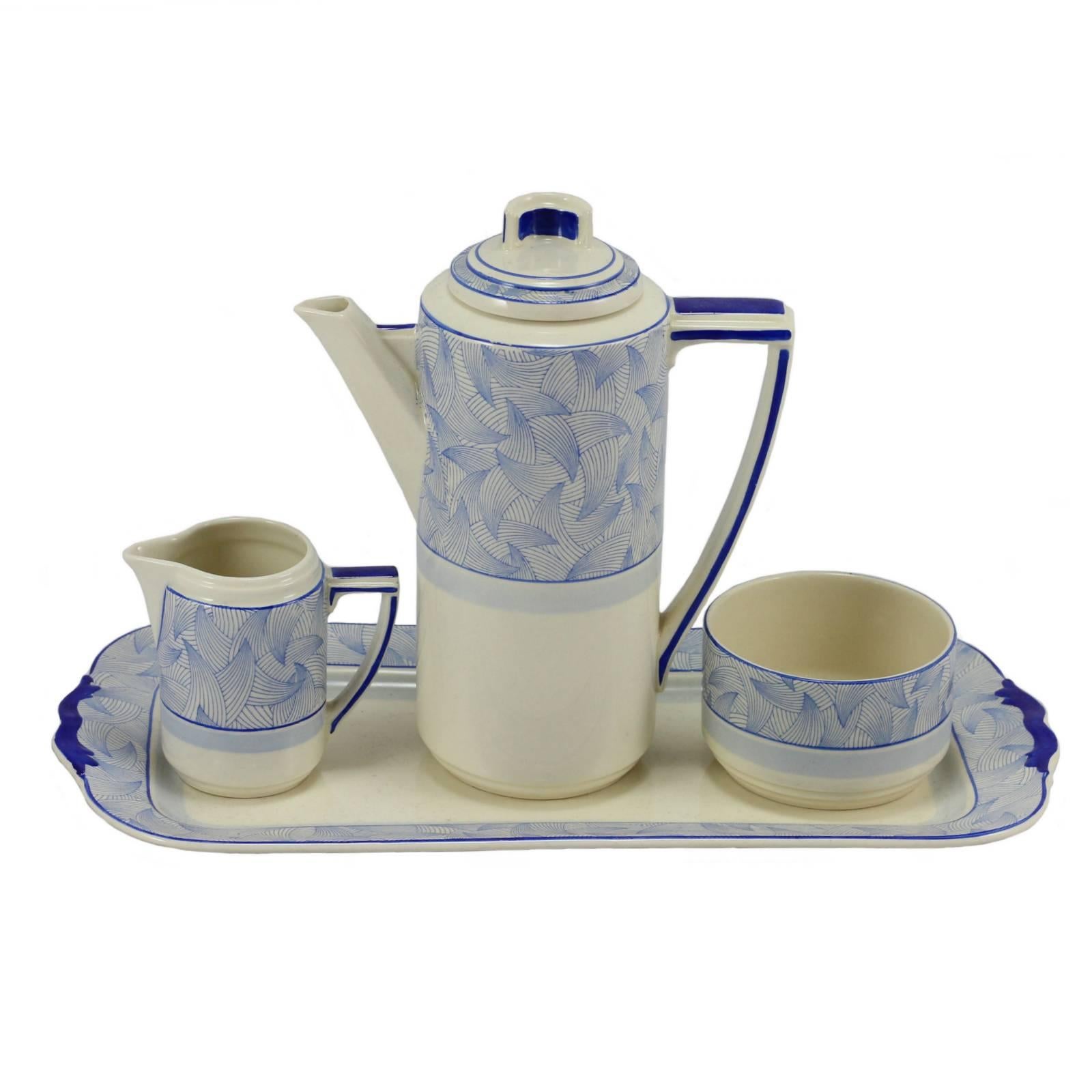 As part of Royal Doulton's foray into the Art Deco style, the Envoy coffee set serves as a prime example of early 20th century modernism with unusual geometric handles, a simple yet striking repeating pattern and a bold use of colour. Sleek and