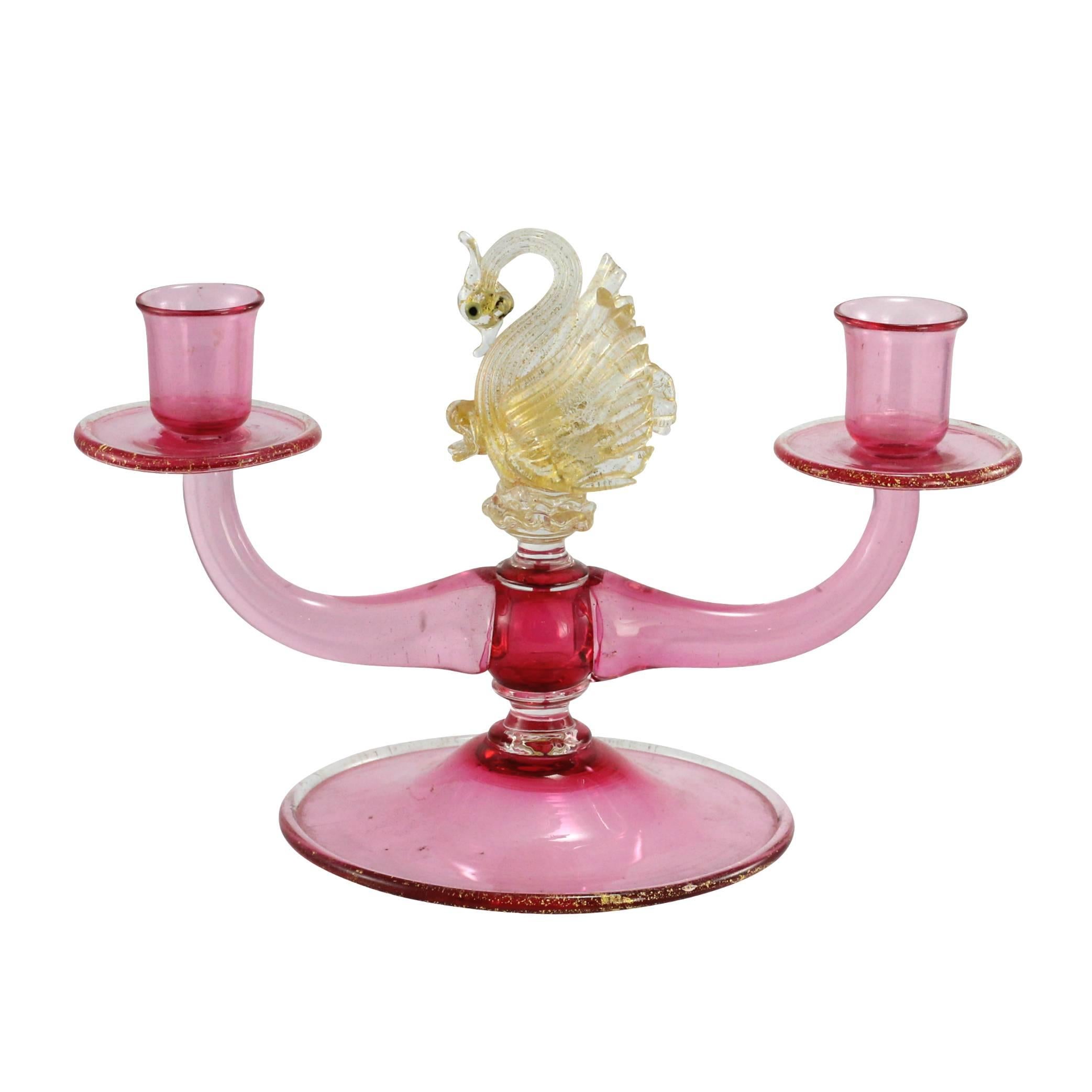 A midcentury, Venetian Murano glass candelabra and swan in gold on a pink base.

Murano, a small Venetian island has been known for its world leading glassworks for centuries. Today, Murano is home to a vast number of factories and a few