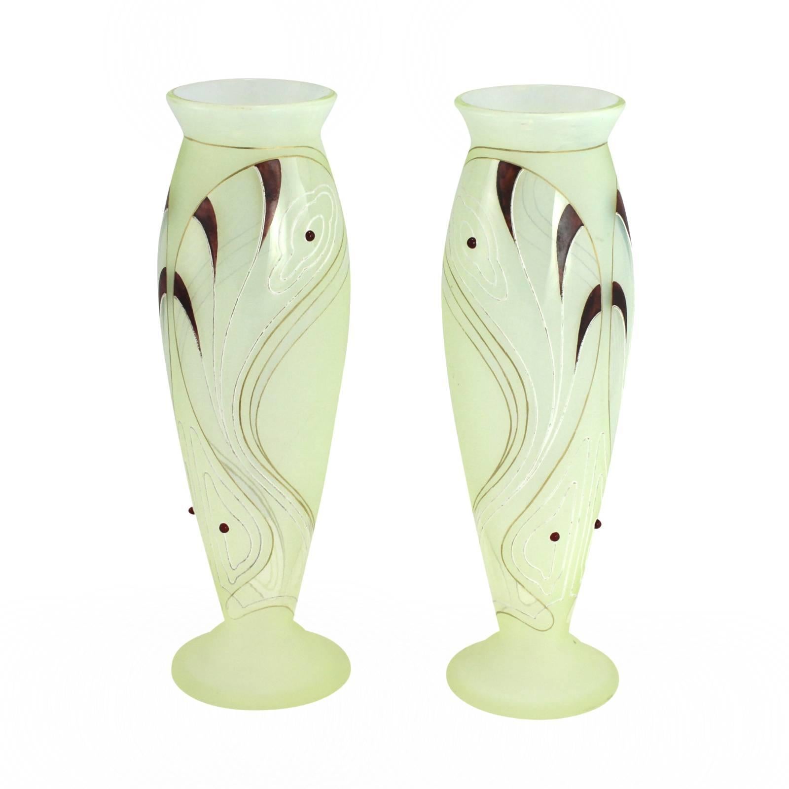 A fine pair of art glass vases in the Art Nouveau taste. They feature a whiplash pattern in burgundy enamel on a uranium glass base with Riedel's signature applied glass jewels.

Today Riedel Glass is especially famous for their contribution to
