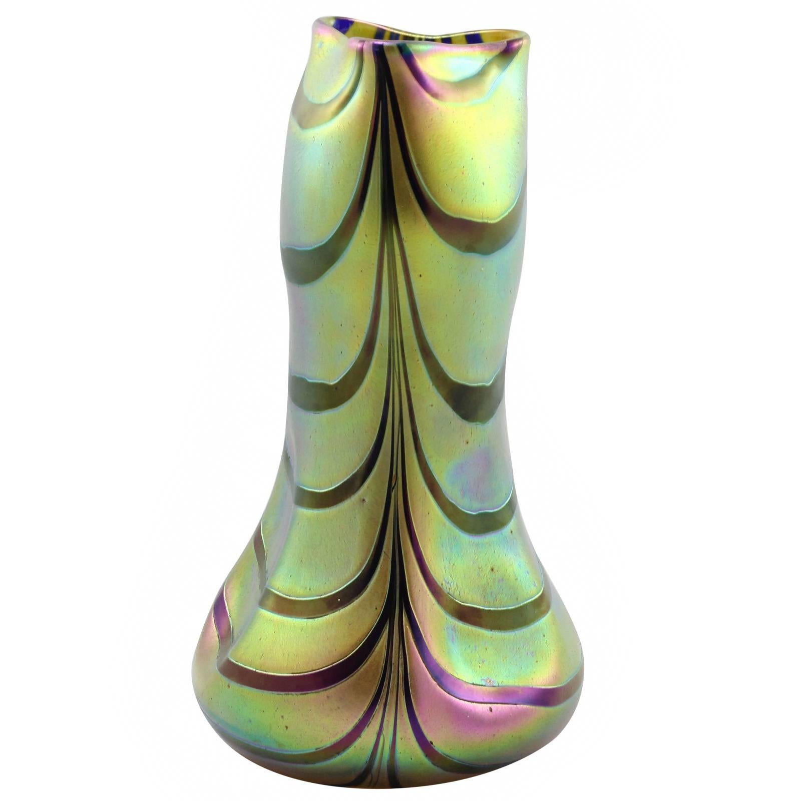 An early 20th century green to yellow iridescent glass vase with violet stripes by Bohemian glass manufacturer Kralik. The distinctive shape of this vase with a globular foot and cabochon indentations indicates this vase was clearly made by the
