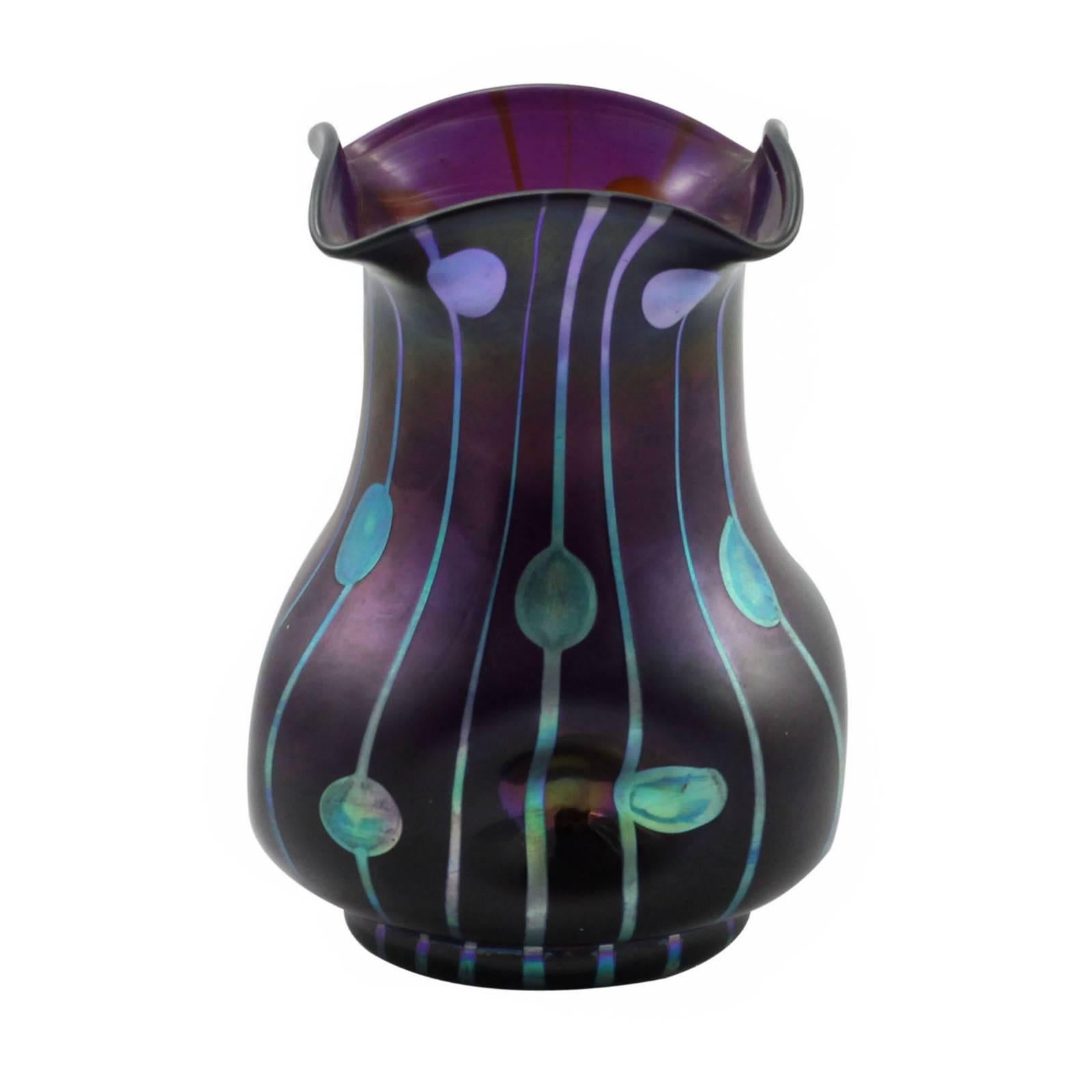 An iridescent glass vase in the 'Streifen und Flecken' decor. The vase features a violet ground with a striped and dotted decor in iridescent blue and silver glaze. It is purported that this vase was designed by Koloman Moser and Josef Hoffmann for