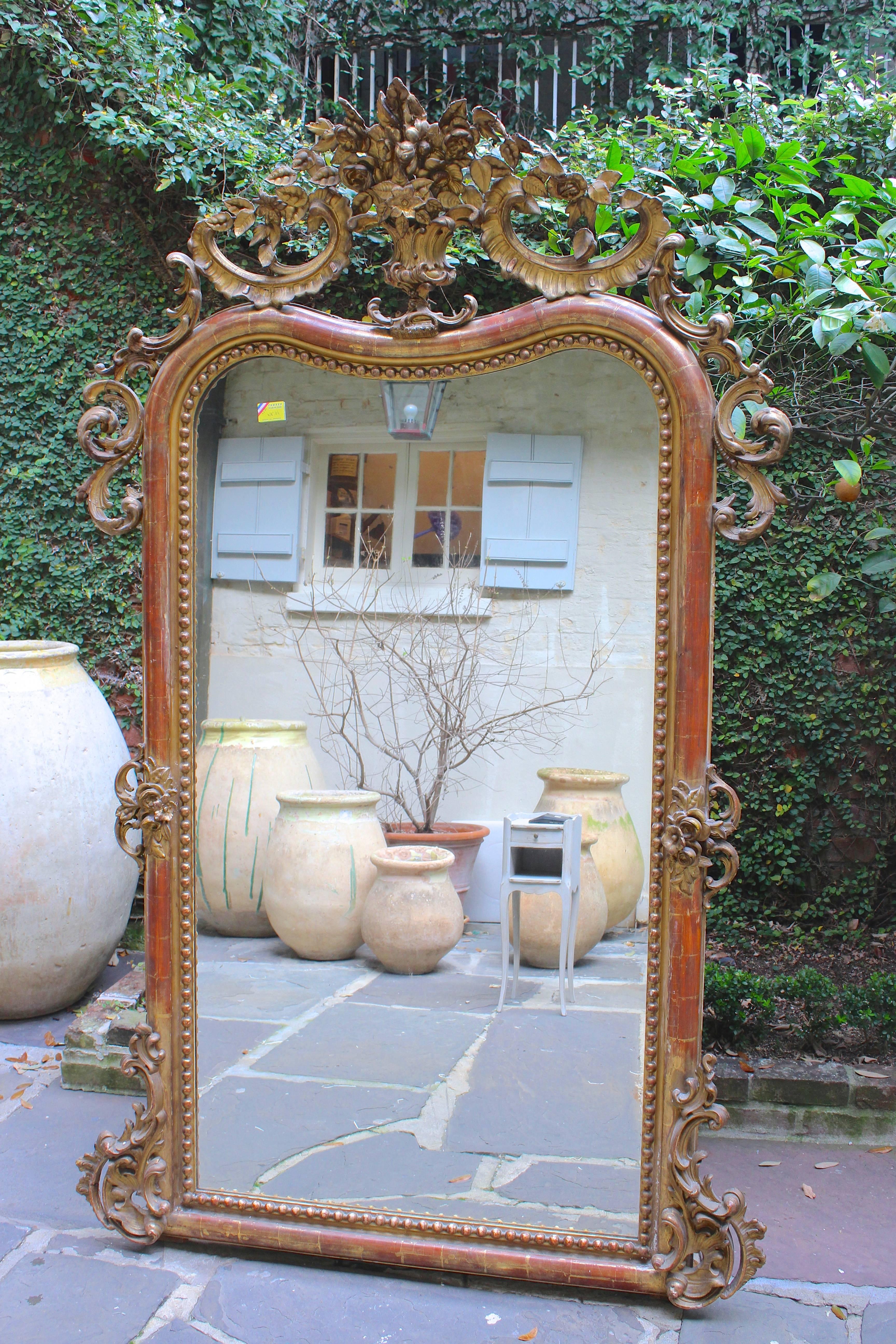 Antique French 19th century Louis XV style mirror with original French paint, gilt, and extremely detailed carvings throughout. Frame with extremely rare curved top and beaded interior.