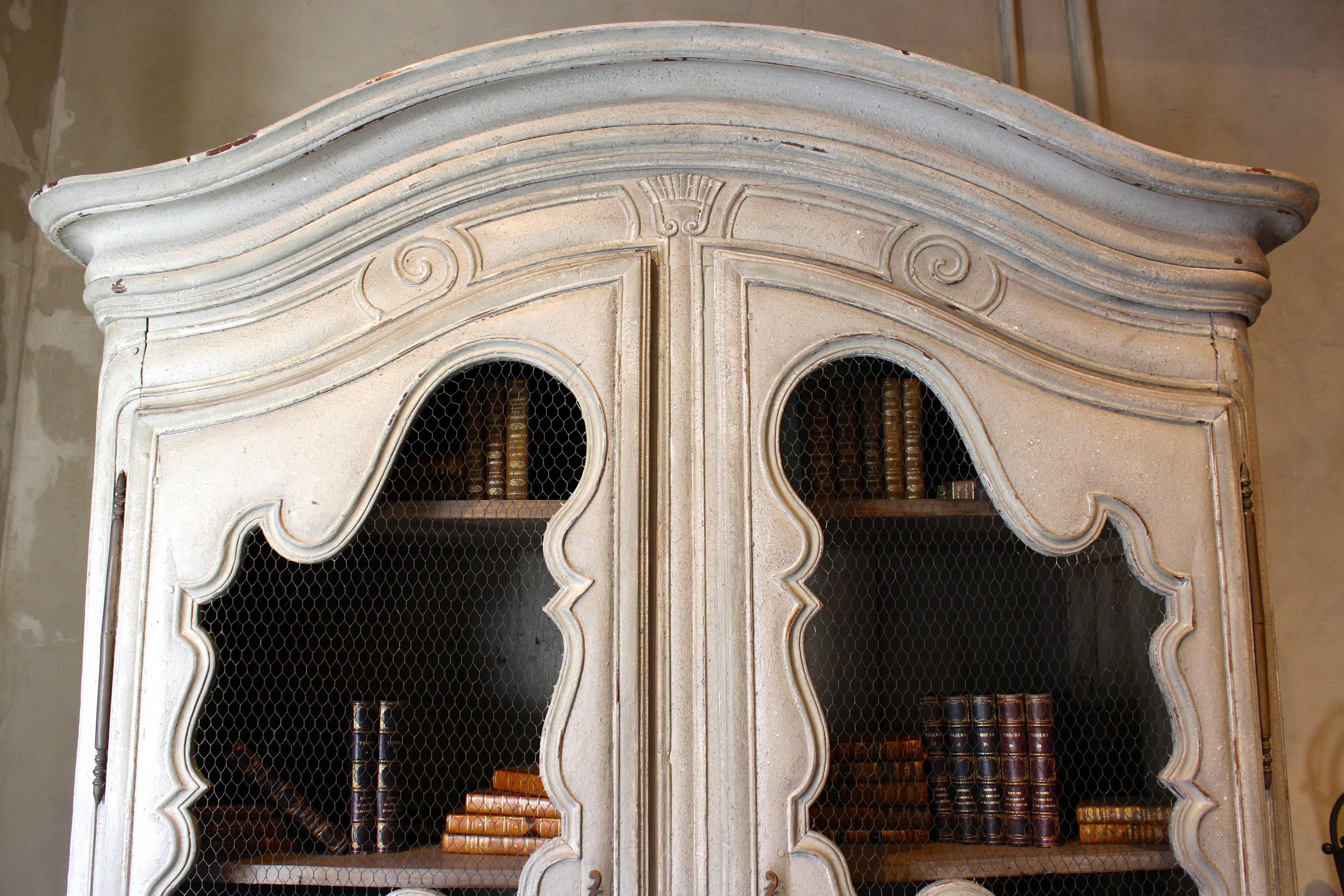 Antique French early 18th century period Regence, Louis XV walnut Bibliothèque with rare curved bonnet and doors, rare bottom drawer and original hardware.