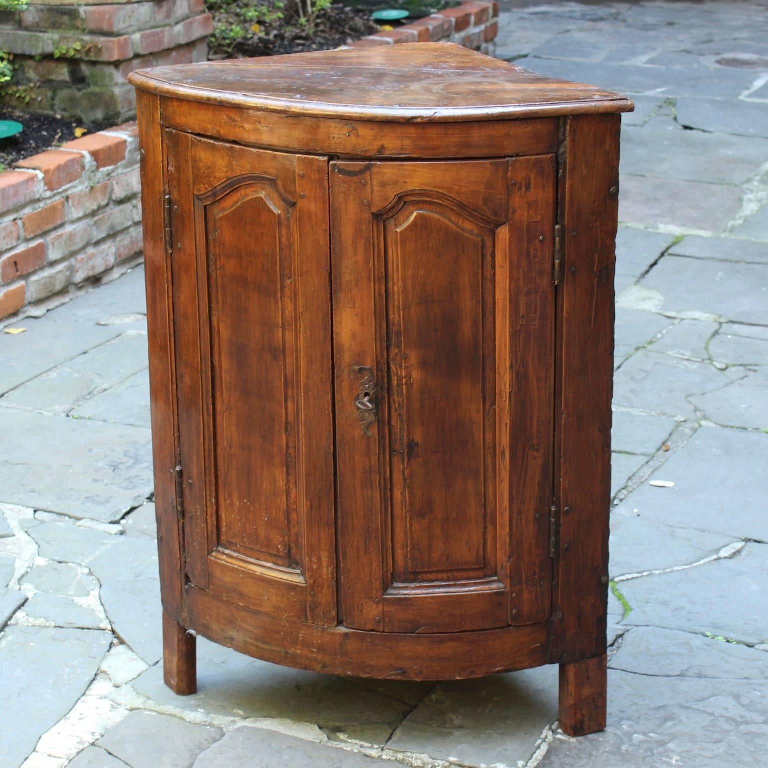Antique French 19th century Encoignure (corner cabinet) with curved front and doors, detailed carvings, and original hardware.