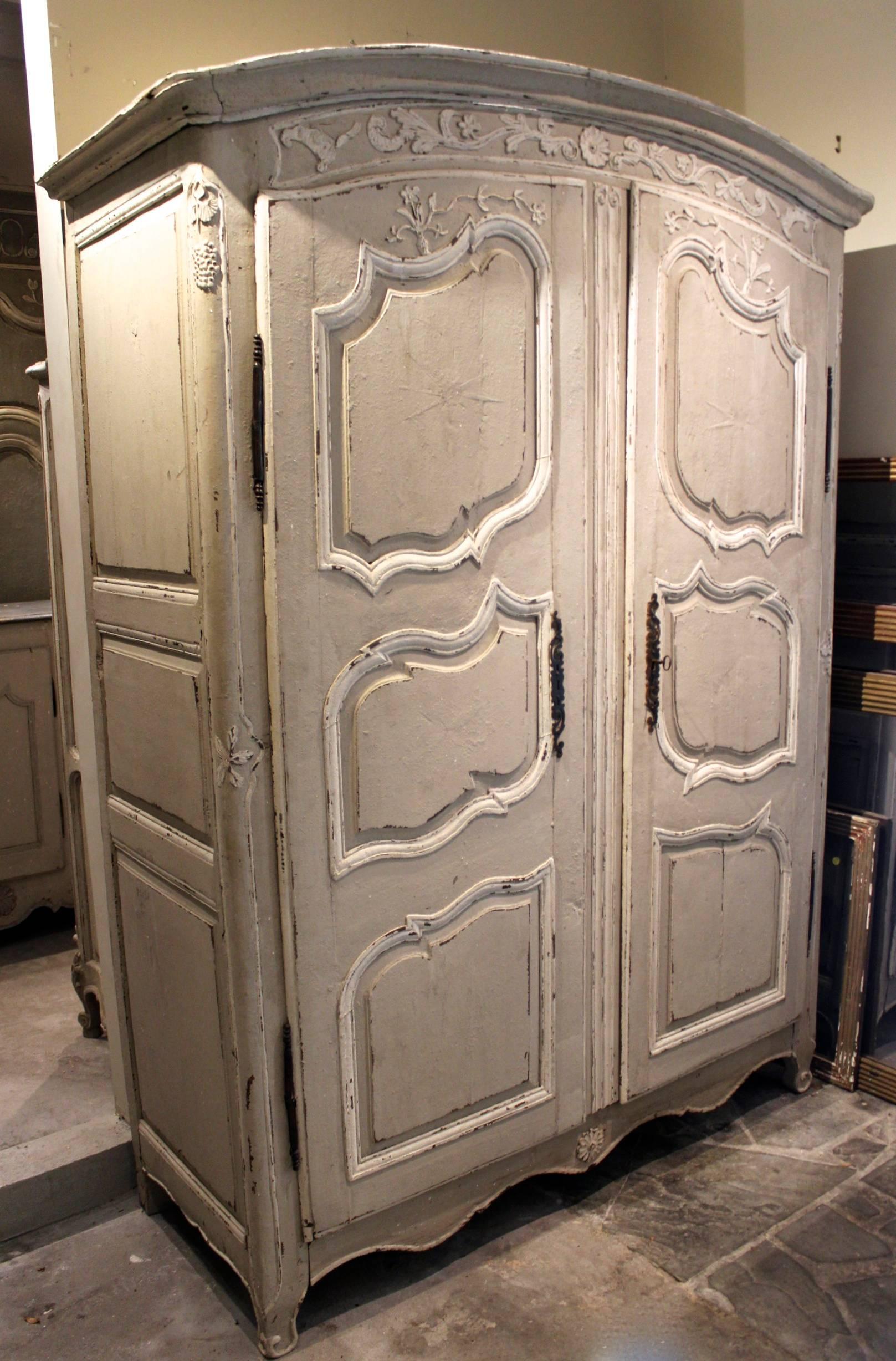 Antique French 18th century Louis XV armoire with rare curved top, detailed carvings, French paint, and original hardware.