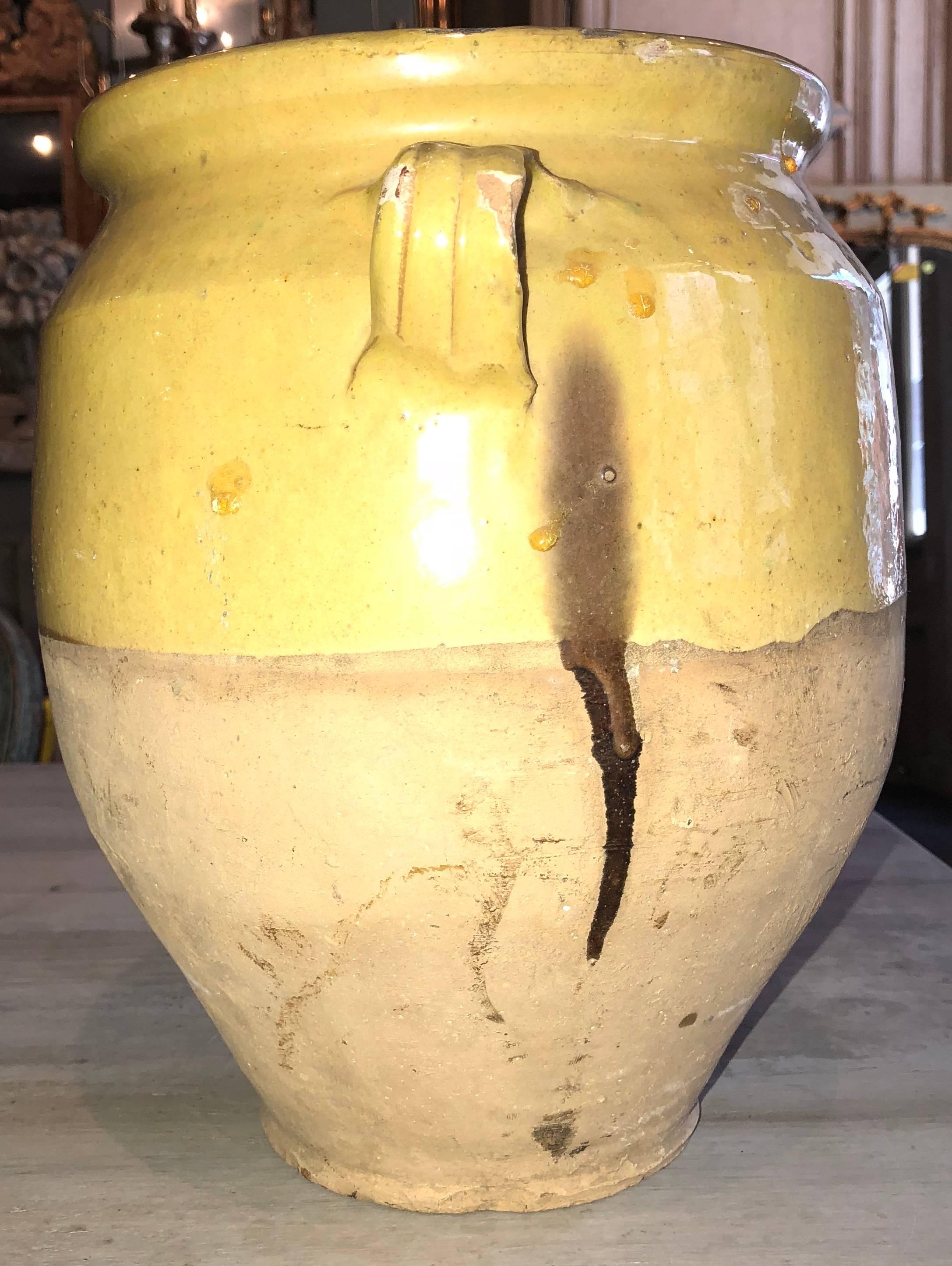 Medium-sized early 20th century French confit jar. This jar features a rare yellow graze, and an even more rare green stripe. In addition, this jar is marked by its' unique patina. 