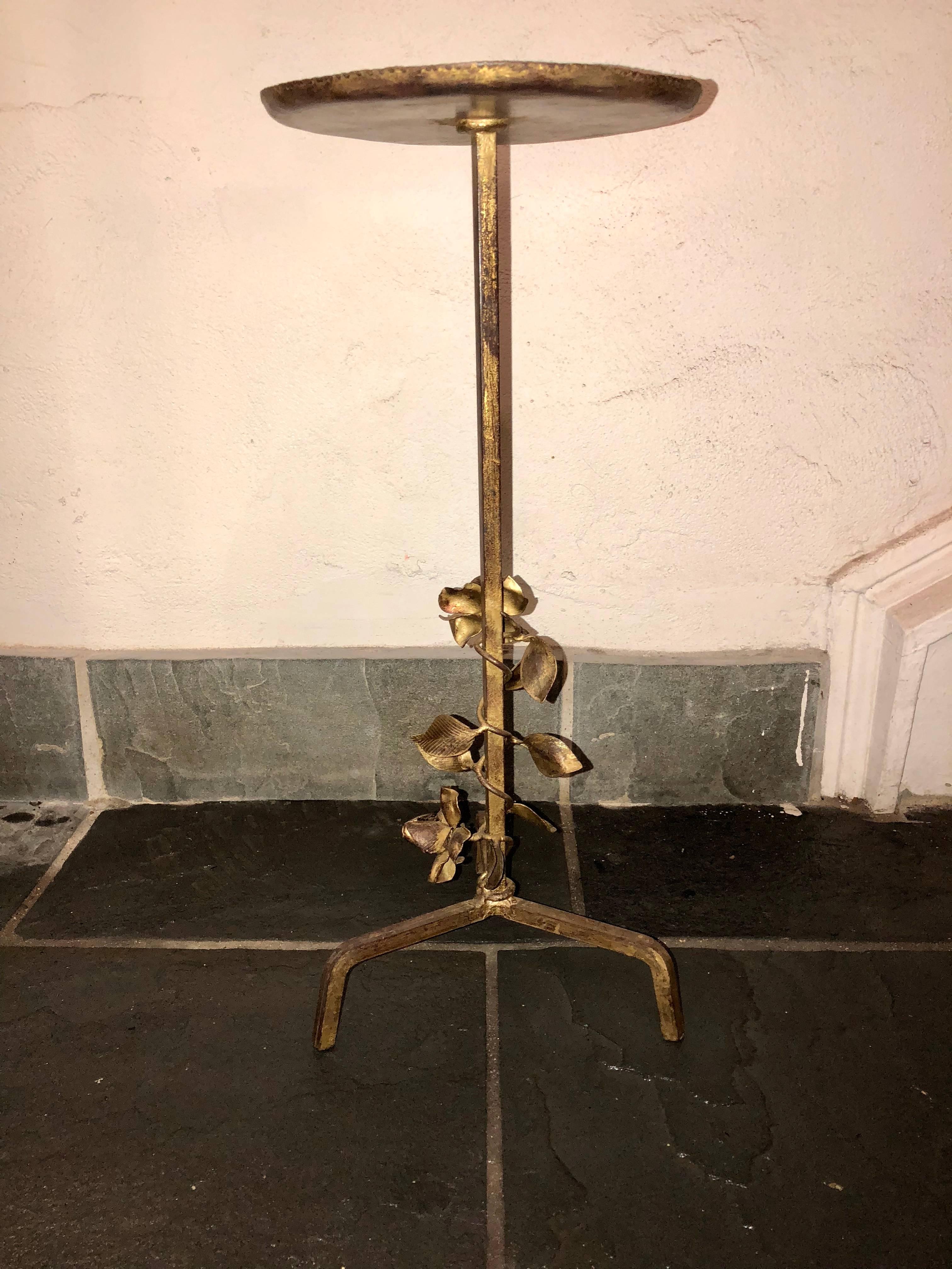 This vintage French martini table is a perfect piece to be nestled beside a canapé or bergère. This piece is made of iron and includes beautiful floral accents on the stem.  