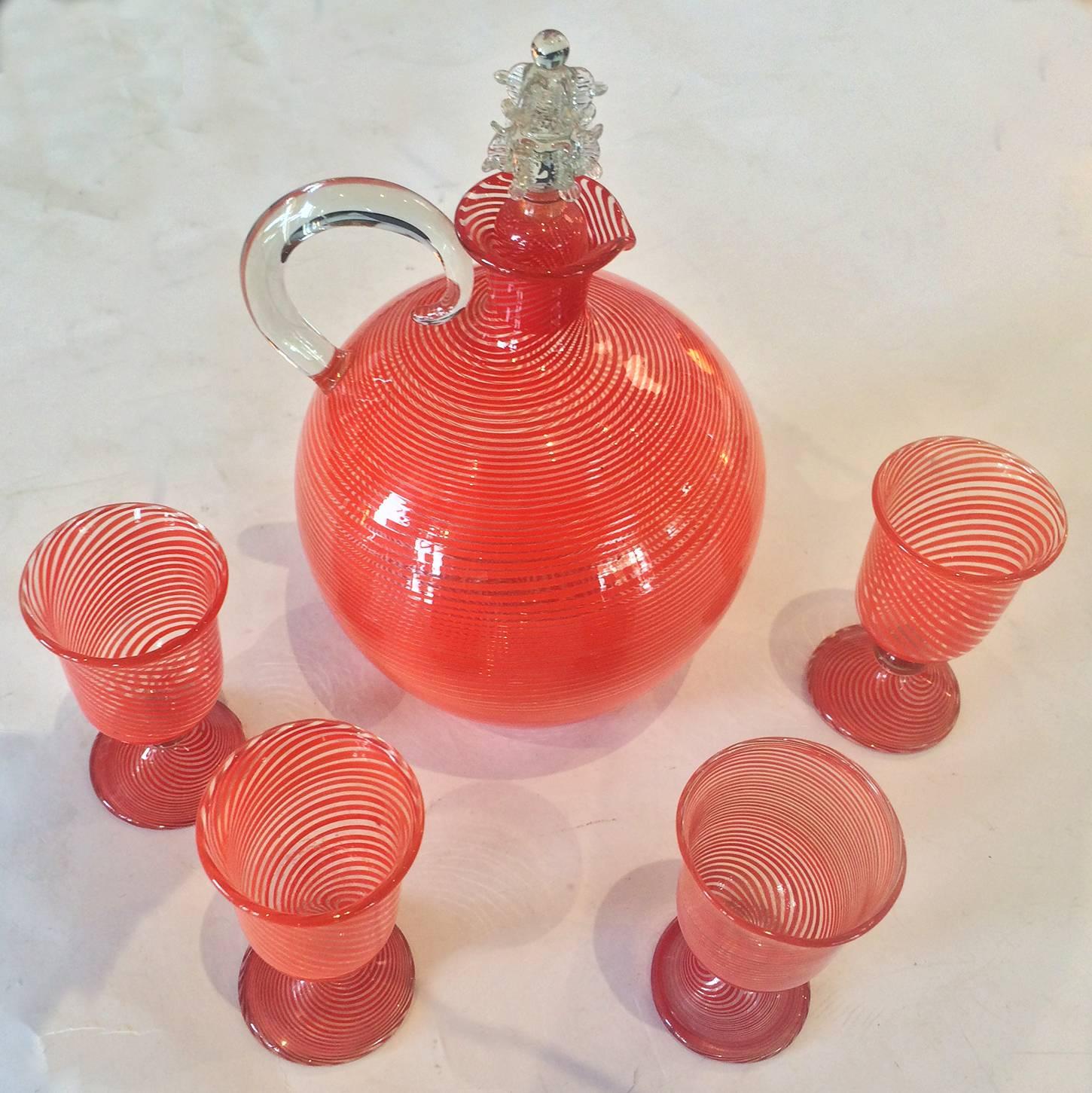 Art Deco decanter and four glasses in brilliant orange spiral pattern. Please note, the handle is nearly “free floating” and is only hot attached at the lower point. By Bimini of Austria. Dimensions are approximate: Liquor glasses, 7cm high x rim