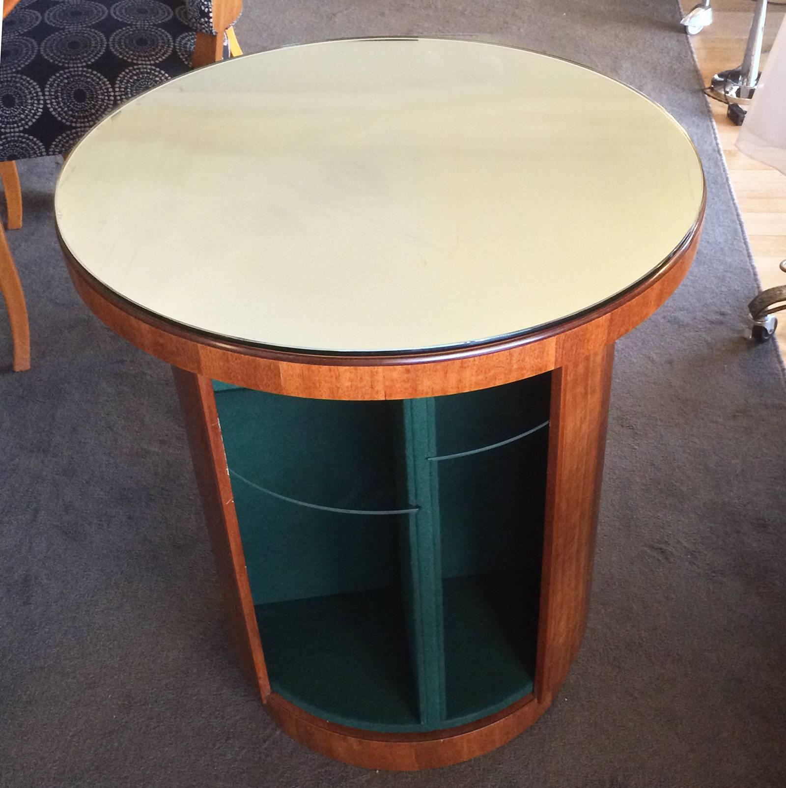 Art Deco, rare round cocktail bar with mirrored top and Rotating inner storage, divided glass shelf areas of various heights. The walls are lined in green felt, and it has a Stepped base. A real statement piece in excellent condition, and in a soft,