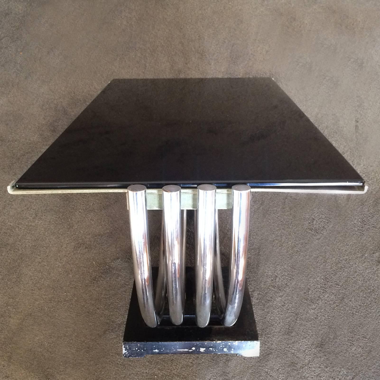 Art Deco table, Machine Age with four-piece, arched semicircle nickel plated tubular supports, with lipped end restraints at the two ends to hold the top; all on a triple stepped, solid iron base, and the original black Vitrolite to top. Original