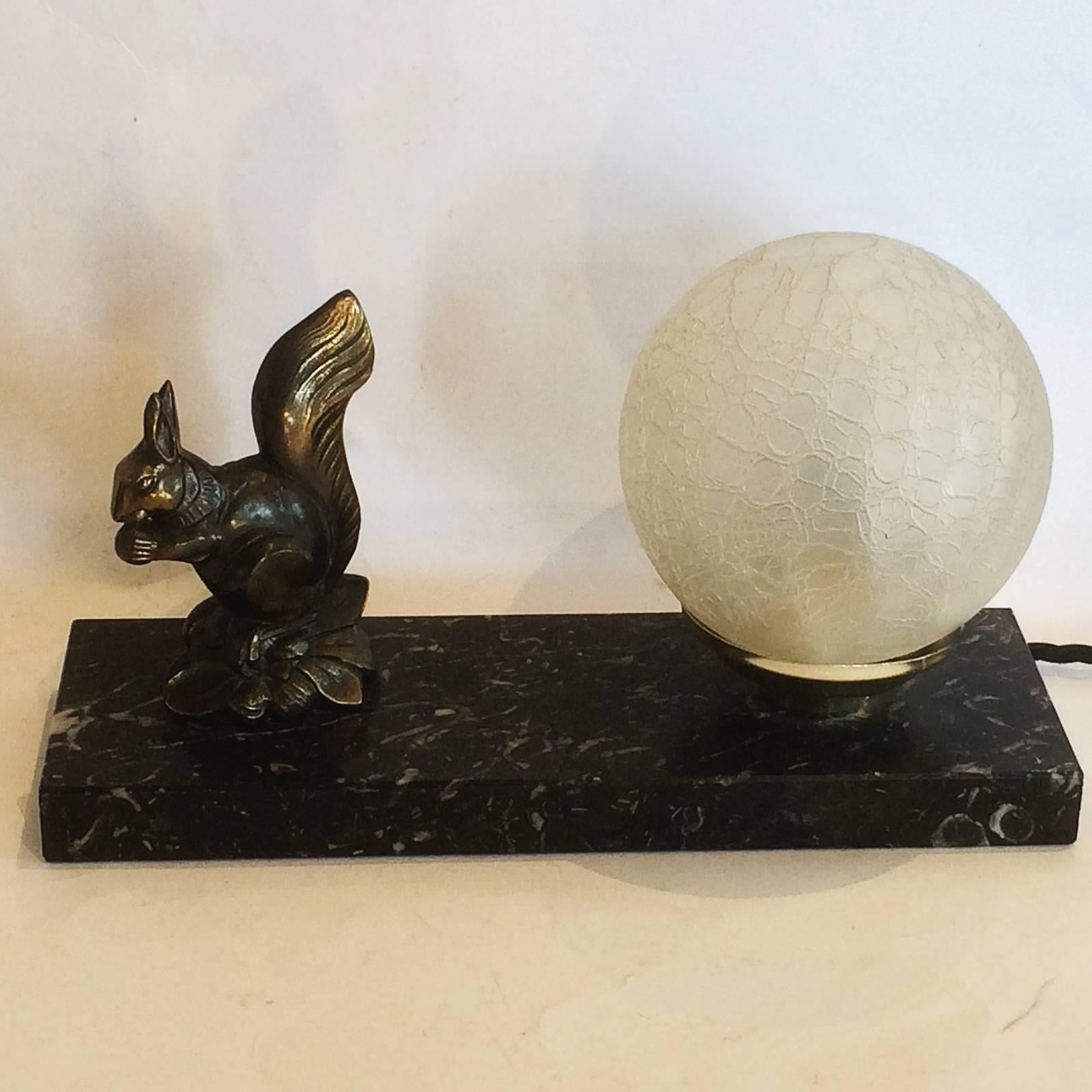 Art Deco French Mood lamp, with black and white veined marble, and a Spelter squirrel bronzed dipped with a finish of black and gilt, and still retaining original “Craquele” finish glass shade. All in excellent condition, a couple of “nibbles” to