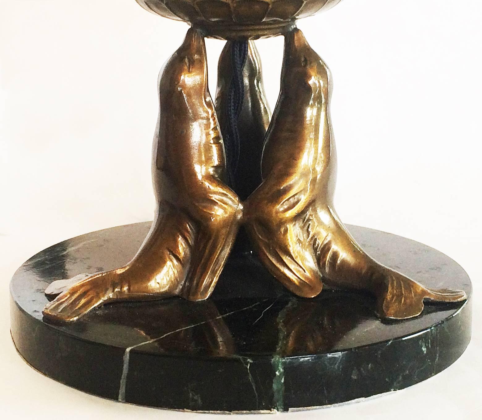Rare Art Deco lamp, with three seals in bronze, supporting a bronze fluted disk, with the original 