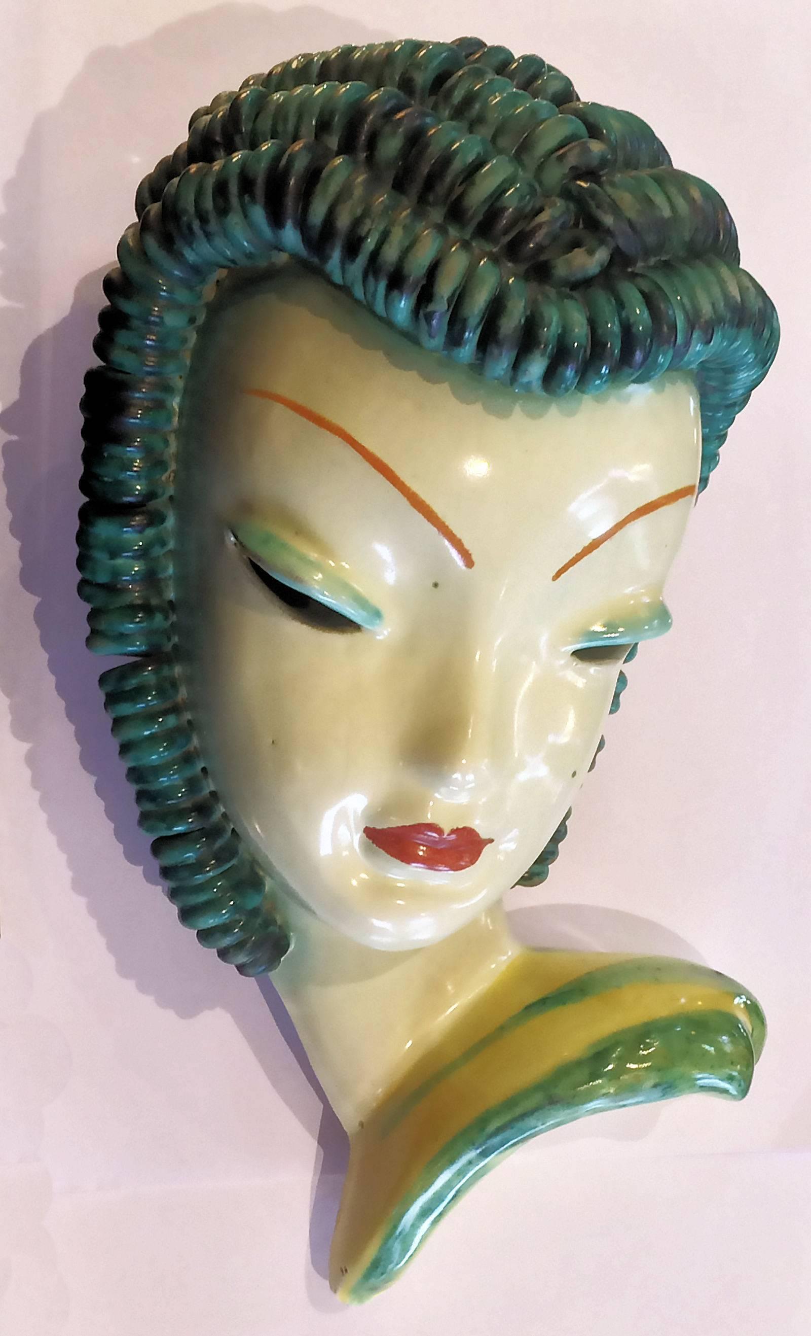 Art Deco mask of a lady with curly hair, in tones of green. Attributed to Goldscheider, as marks to rear cavity, “1155”, over “HD” underlined condition is excellent, with no damage or restoration, a little of fine crazing over face area and three