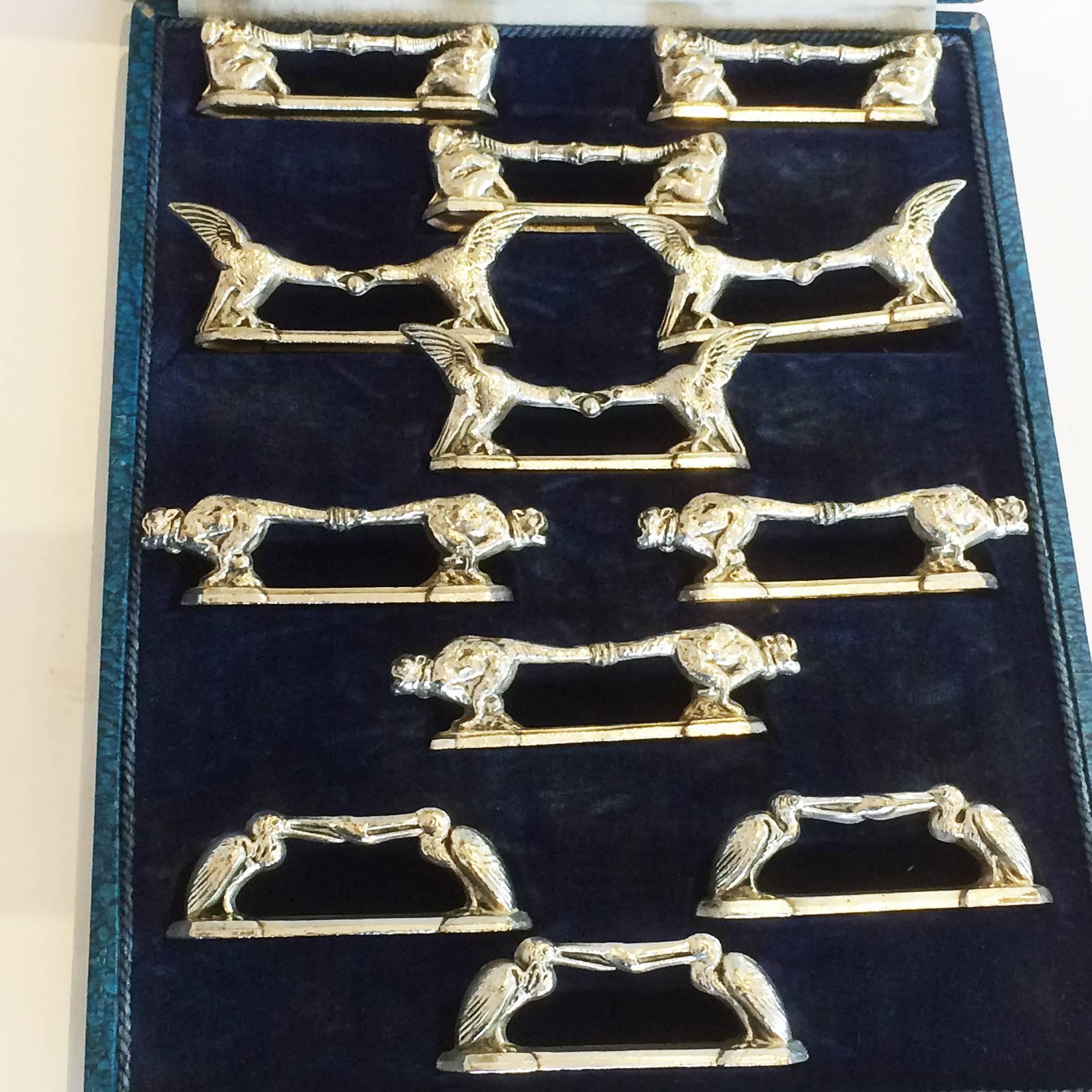 Rare boxed original set of 12 French Art Deco knife rests. Elephants, birds, pelicans, etc. Possibly Benjamin Rabier in nickel silver. All in excellent condition with soft aged patina, no damage, no repairs or losses. 
Dimensions are approx..: 75mm