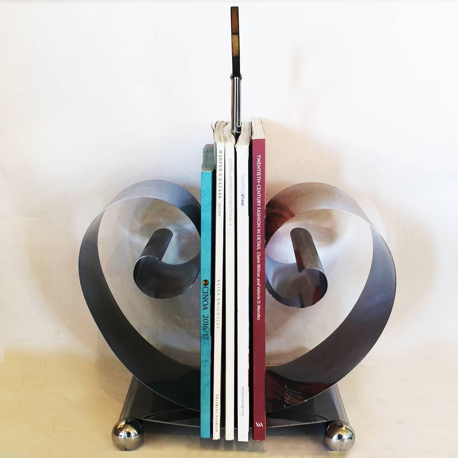 Art Deco, very rare magazine holder in chrome by Revere, registered design for Paris, over N.Y. As marked to the base. An ingenious design, with the springs unwinding as you add magazines to either side; number of magazines held, obviously vary with