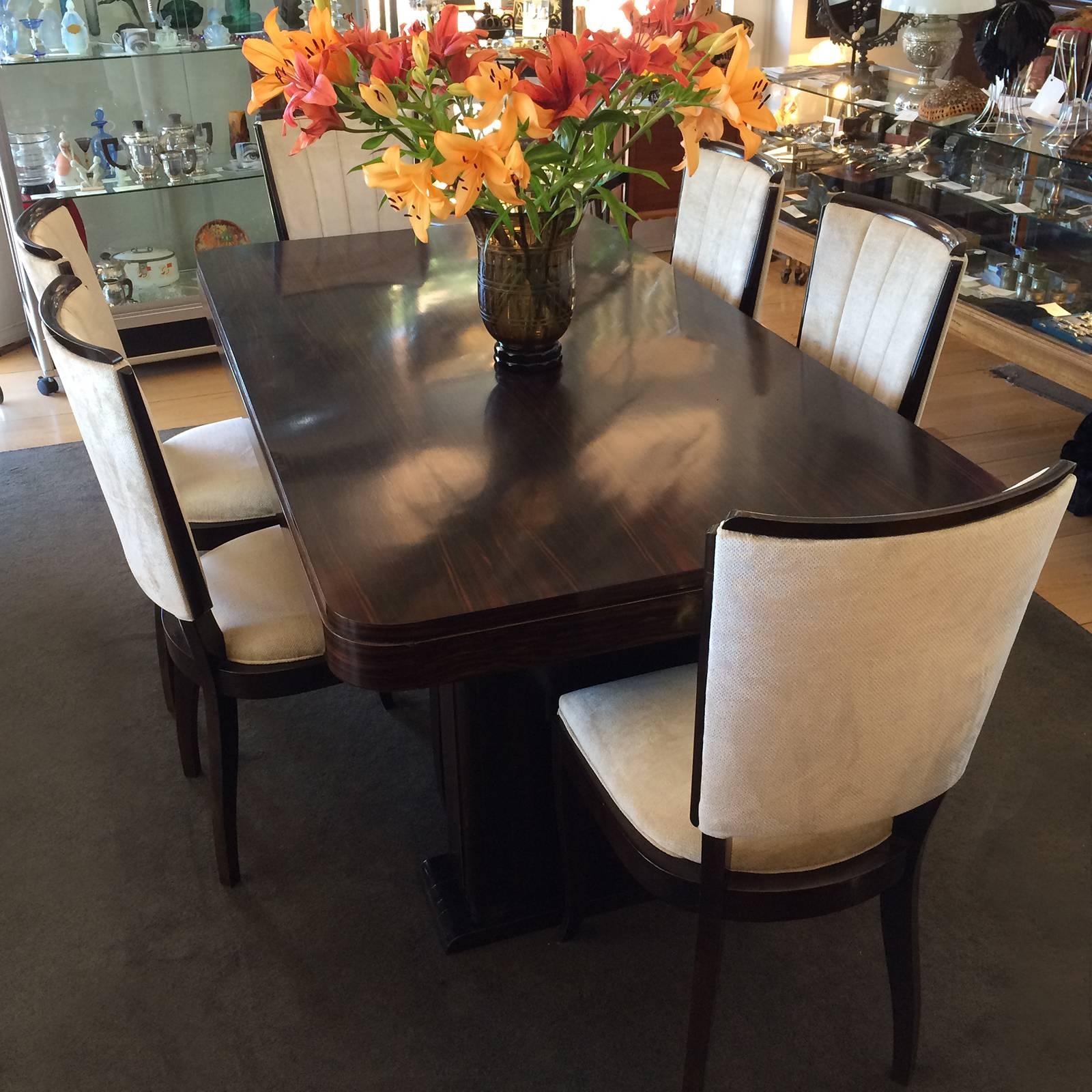 Art deco French Macassar dining suite, including two original ebonized extension leaves for table, and six Macassar upholstered dining chairs with vertical pleats to the back rests and ebonized timber trims. All in immaculate condition. Dimensions