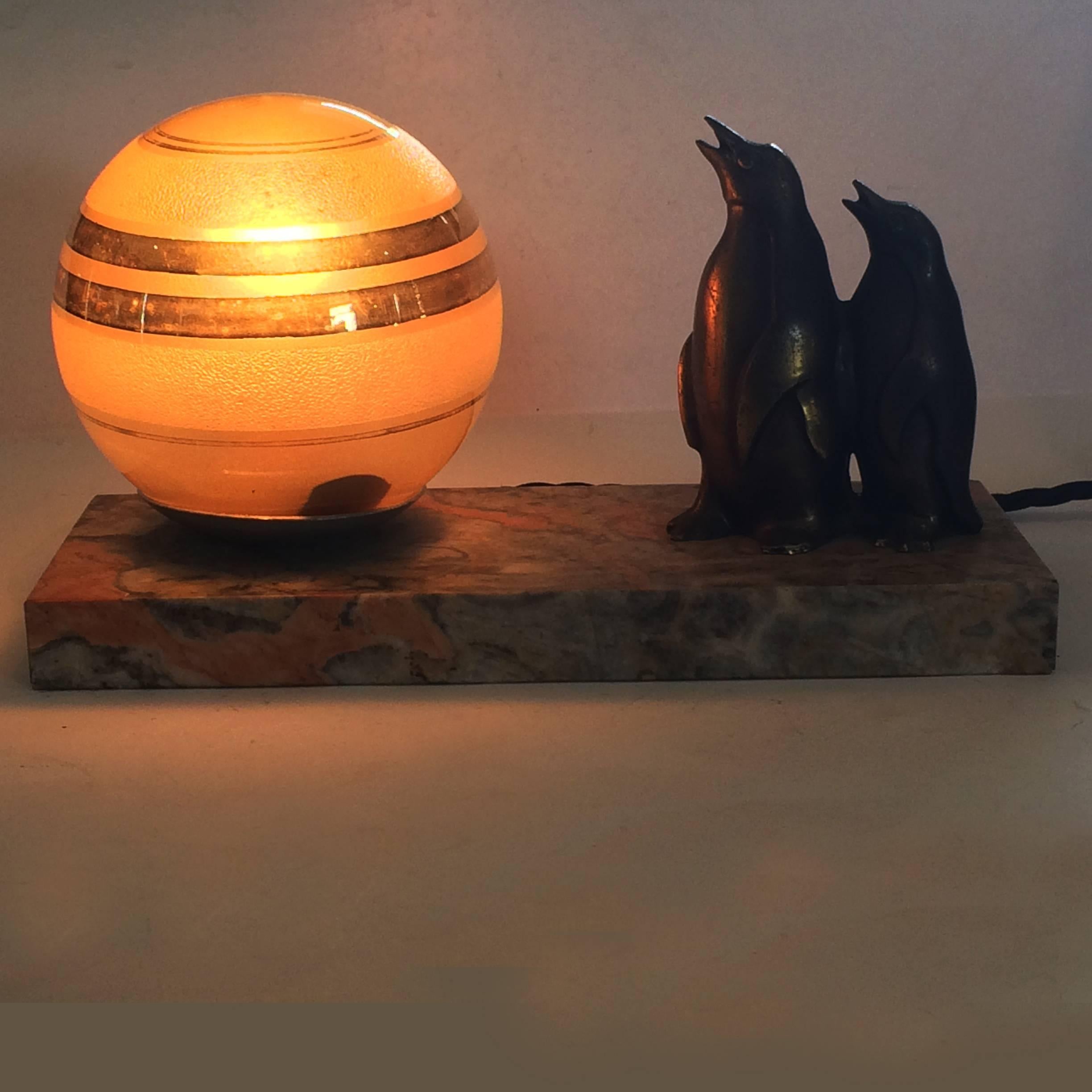 Art Deco Mood lamp, with Font de Art pair of penguins and rings of Saturn sphere glass shade, all on an unusual marble of orange, grey and white colored base. All in excellent condition, re-wired to current standards, but easily changed to suit