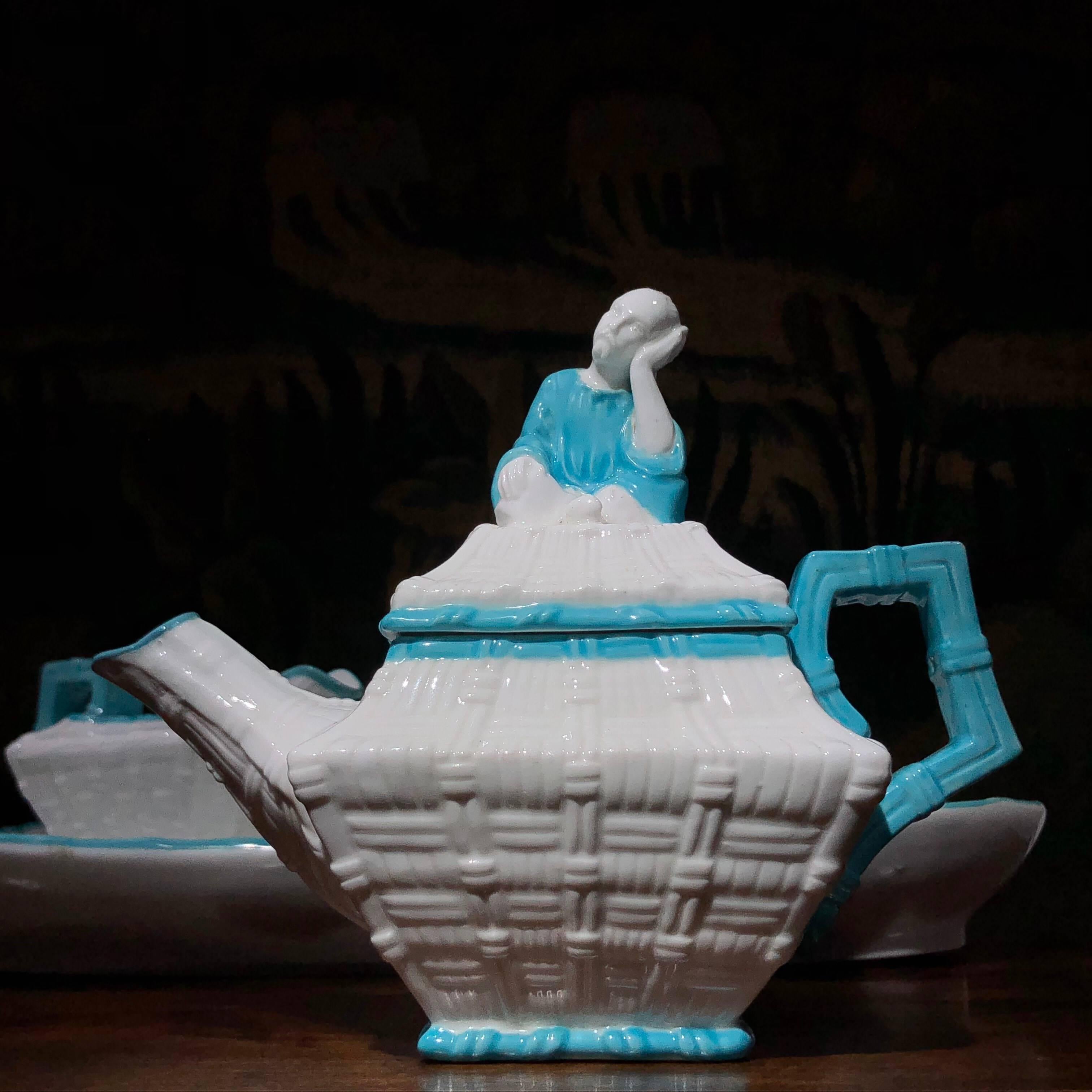 English bone China cabaret set in the chinoiserie manner, moulded as wicker baskets with oriental figures sitting on top, with highlights in a soft turquoise. 

Impressed mark to saucer 'CF', for Charles Ford of Cannon Street, Staffordshire,
