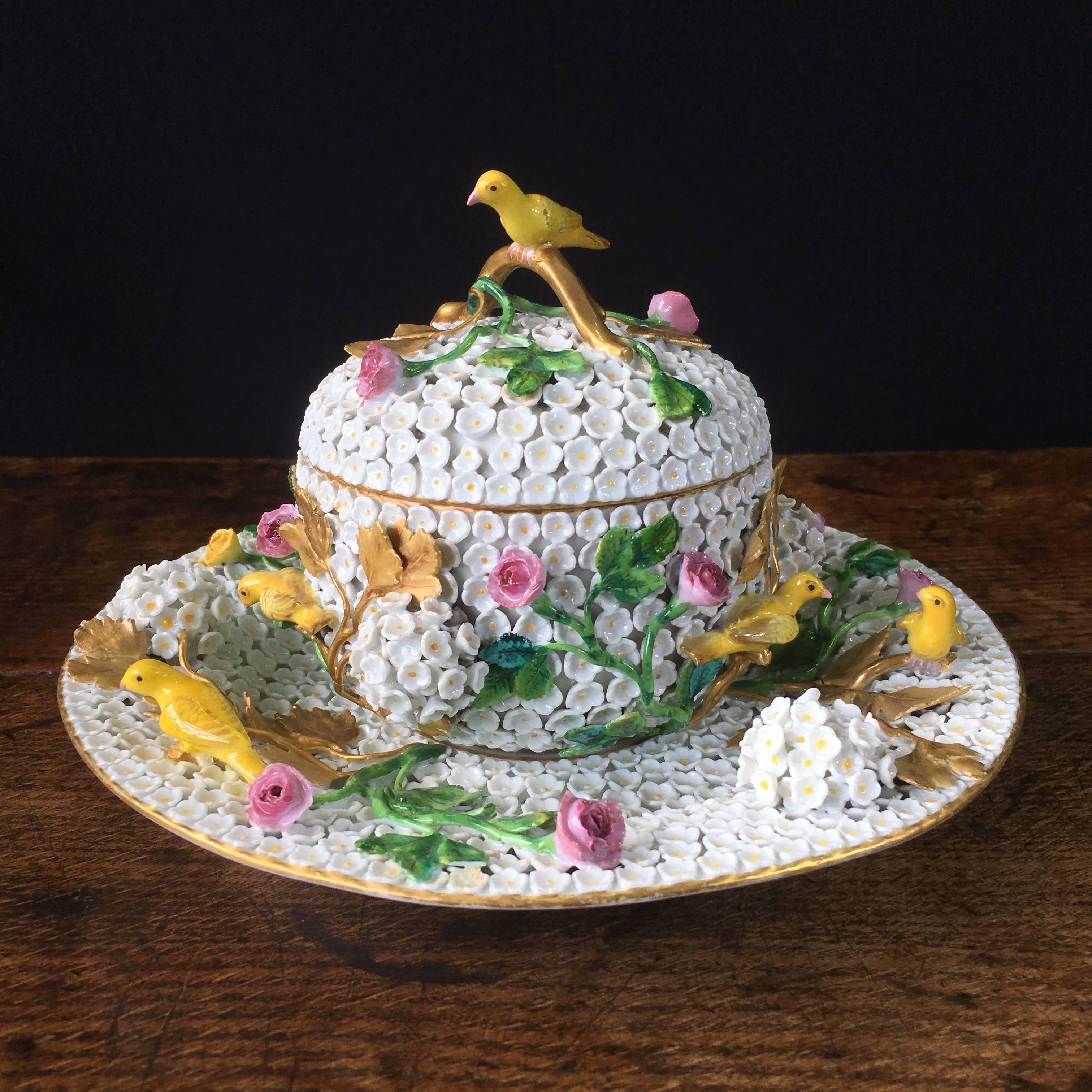 Meissen ‘schneeballen’ covered bowl on stand, applied all-over with small flowerheads, rose branches with buds and leaves and yellow birds, the lid with a twig handle and bird finial, the branches either gilt or naturalistically colored. Crossed